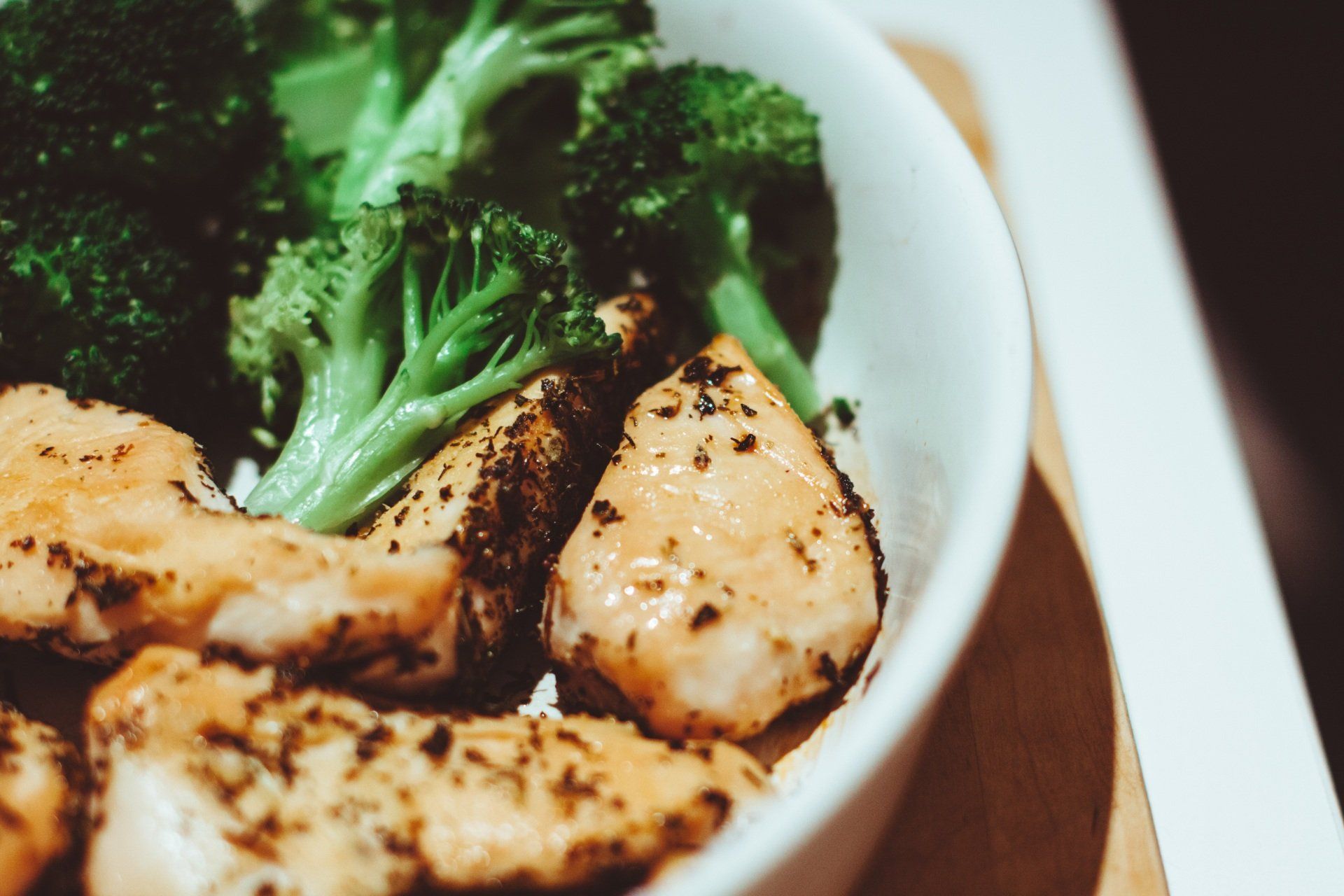A bowl of chicken and broccoli on a table.