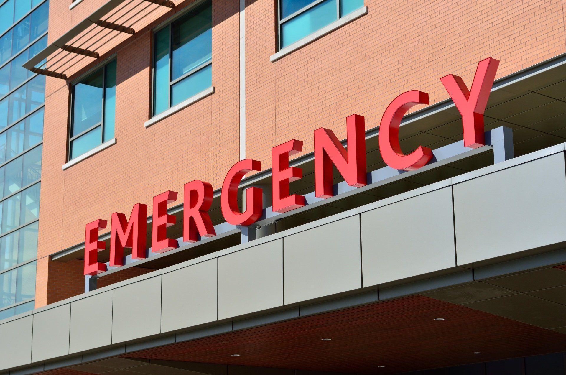 The word emergency is on the side of a building with a outside general counsel.