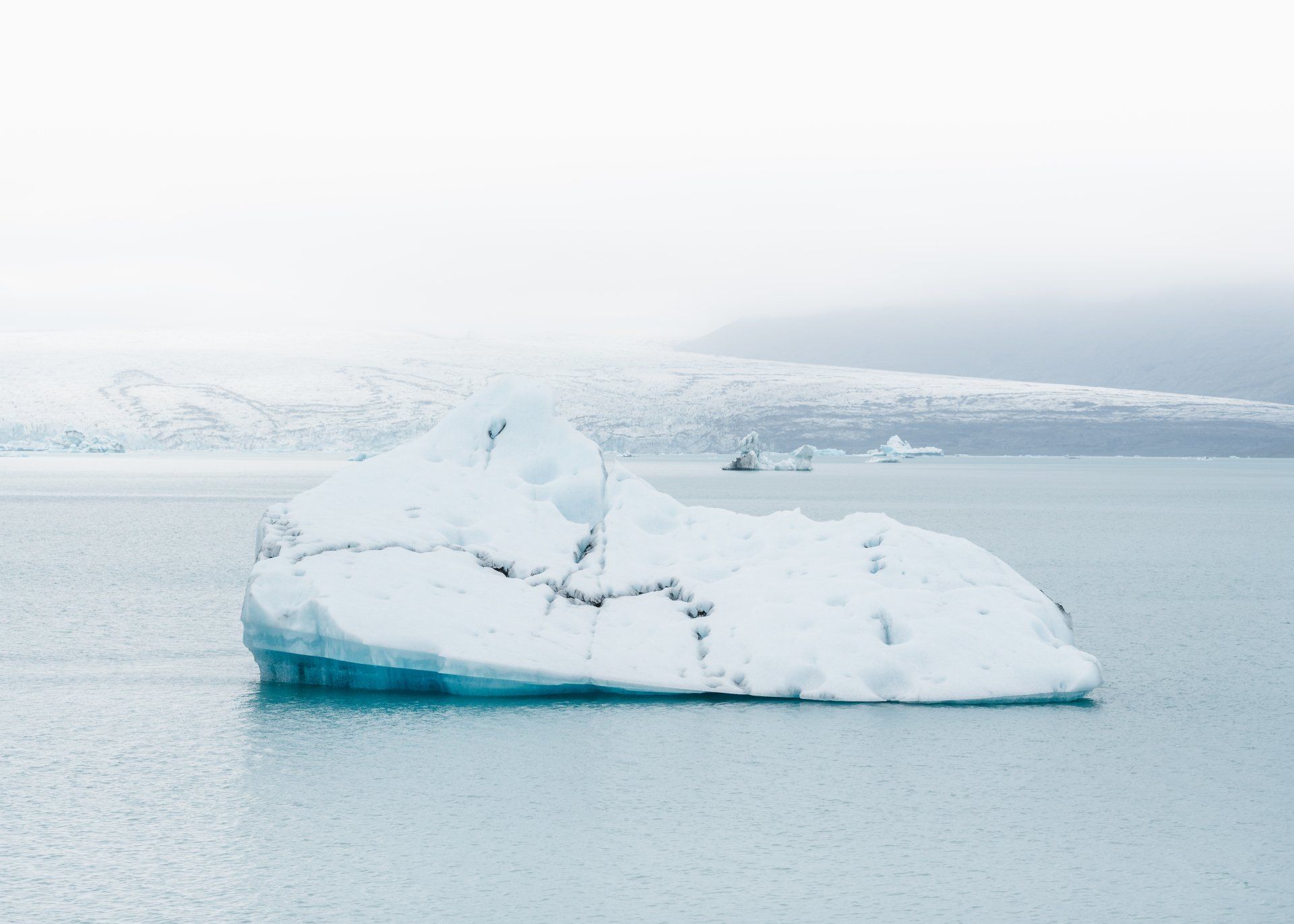 A large iceberg is floating on top of a body of water.