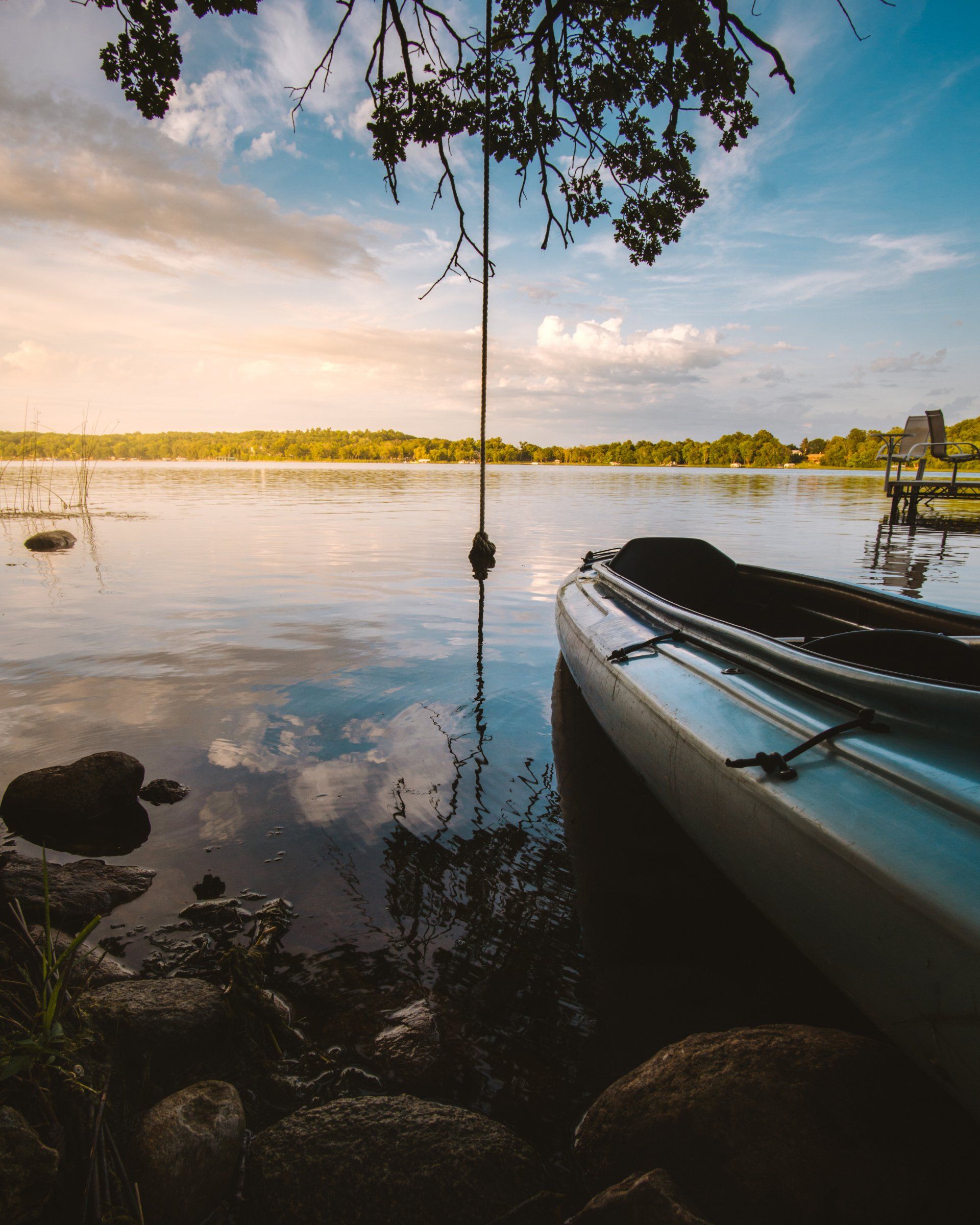 A kayak is sitting on the shore of a lake