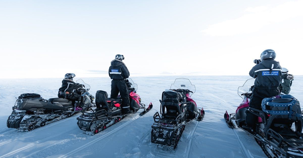 A group of people are riding snowmobiles in the snow.