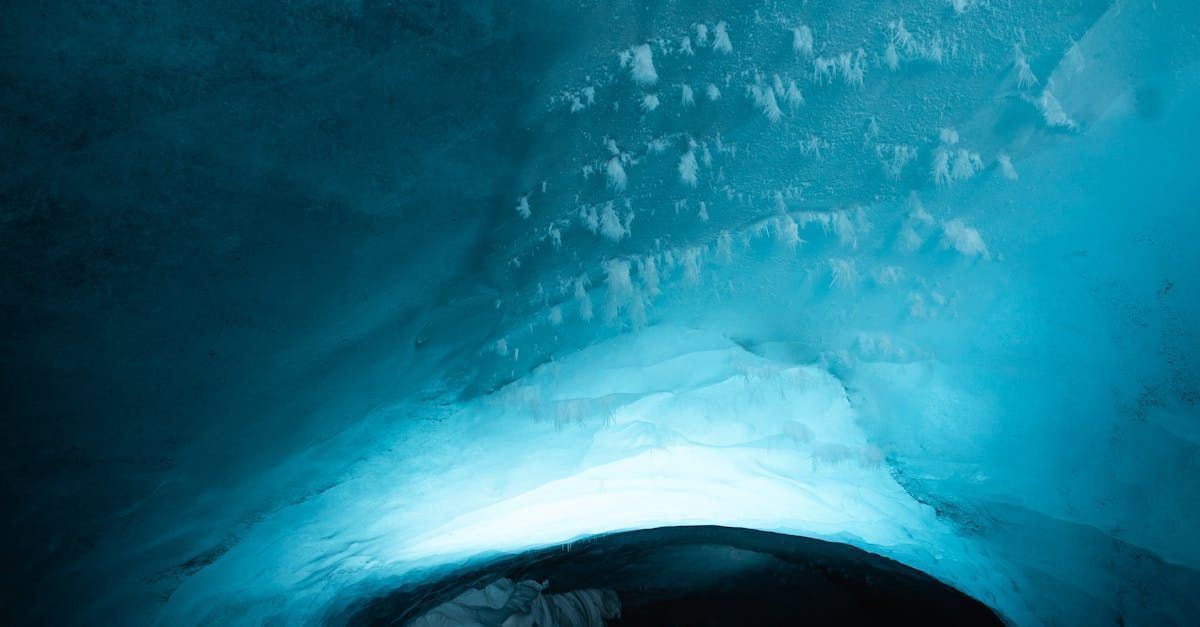 A person is swimming in a cave filled with ice and water.