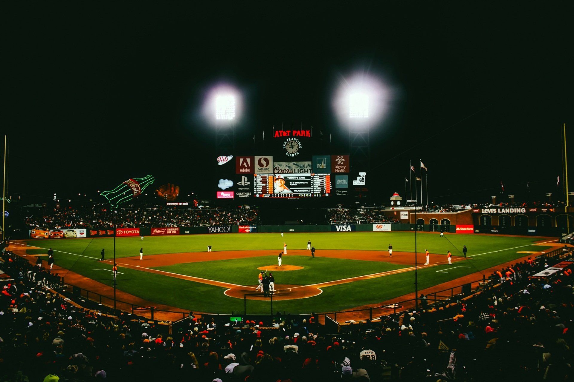 A baseball game is being played in a stadium at night. with a sports law.