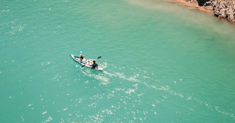 An aerial view of a person in a kayak in the ocean.