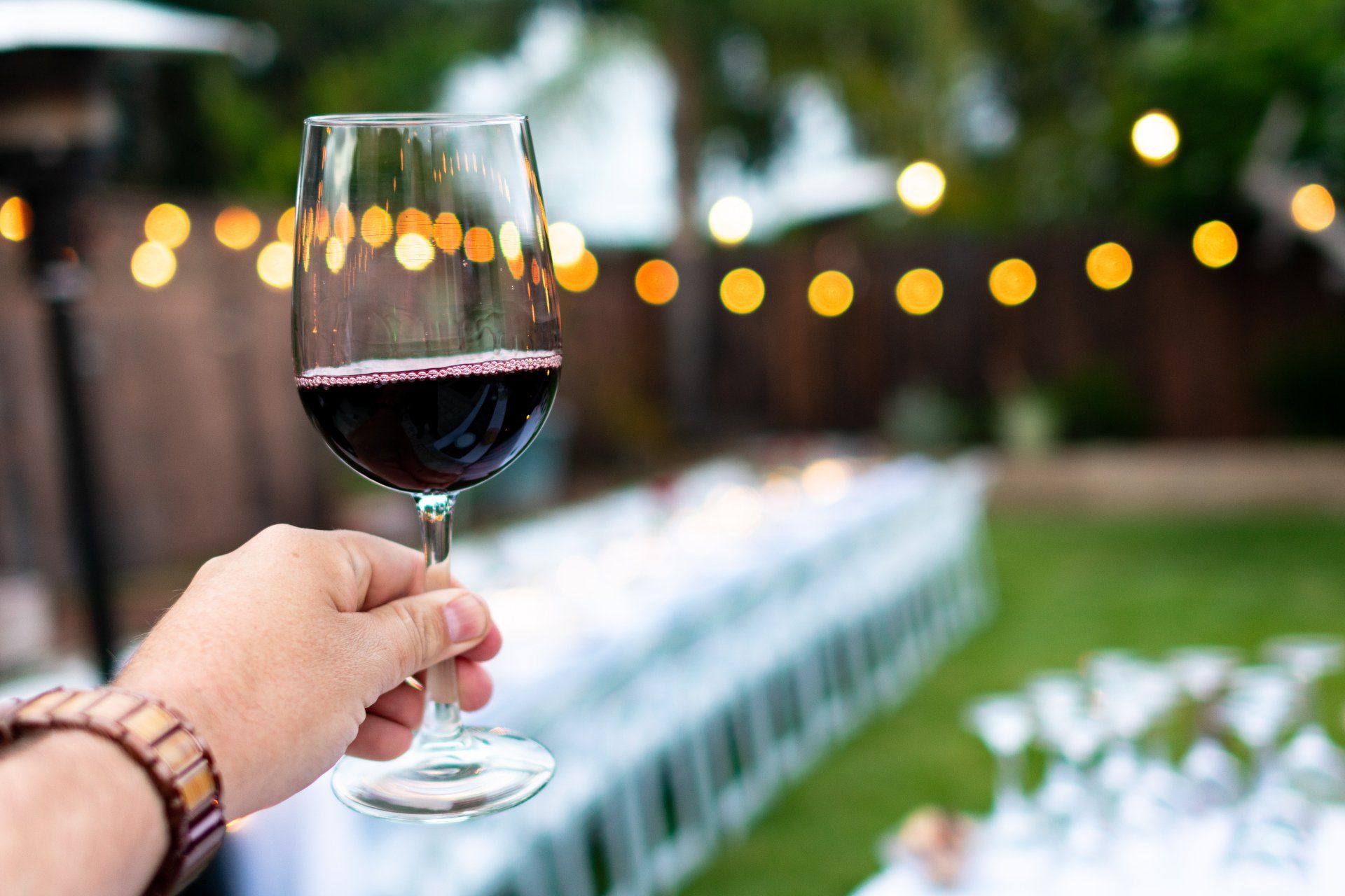 A person is holding a glass of red wine in their hand.