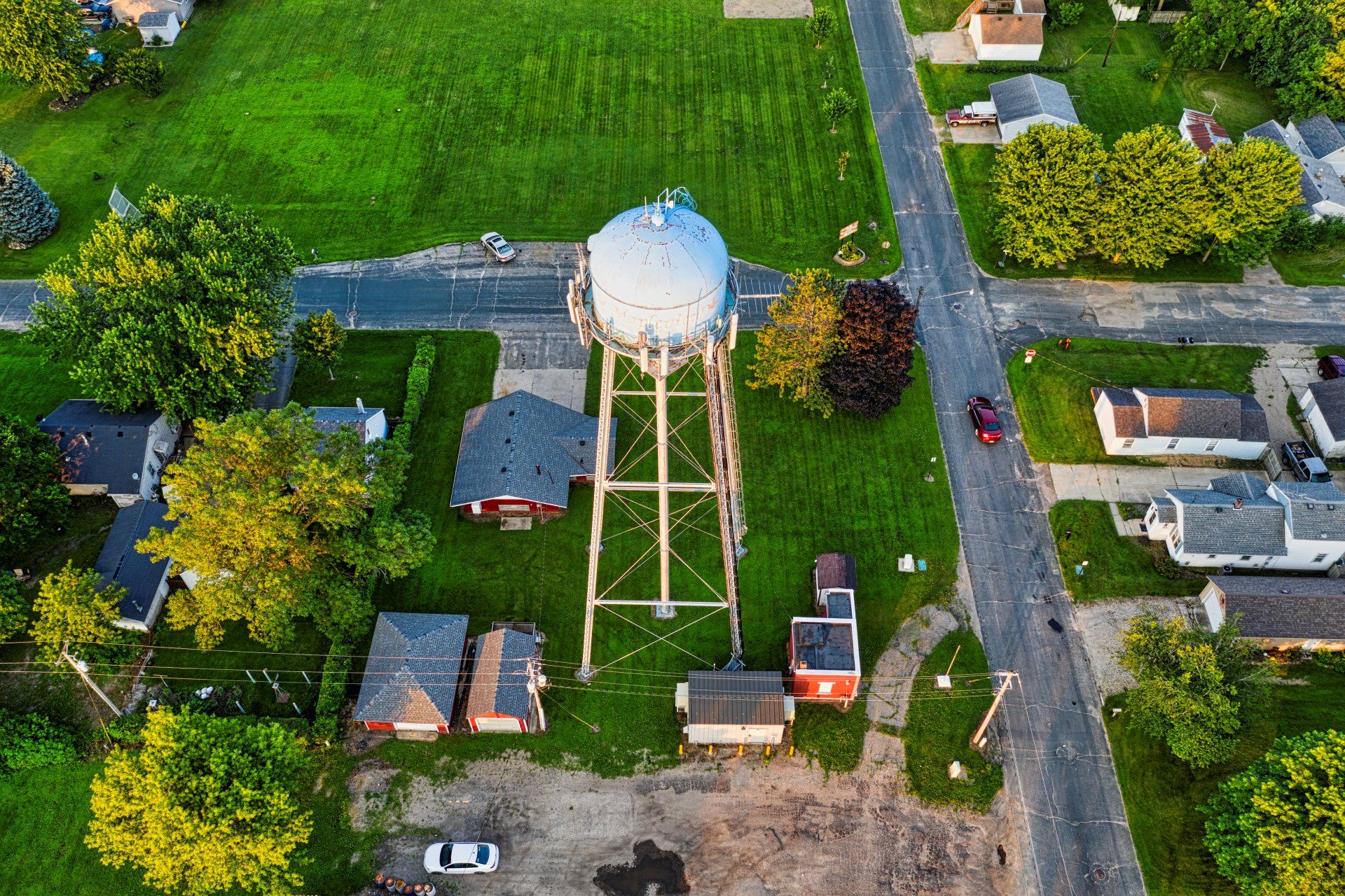 An aerial view of a water tower in the middle of a residential area.