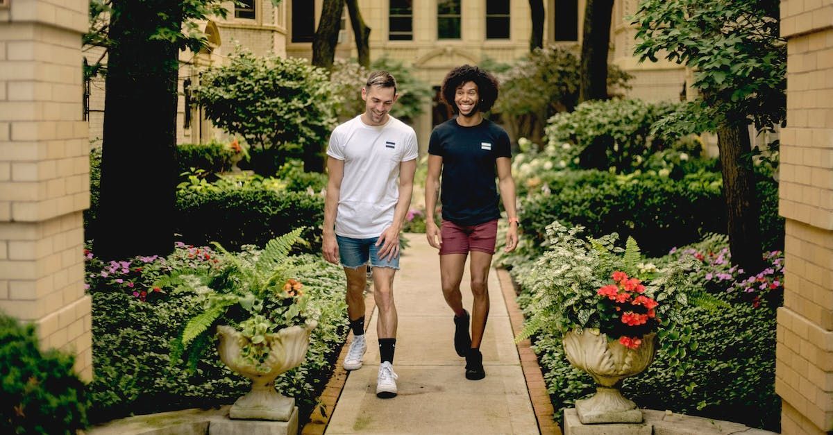 Two men are walking down a path in a garden.