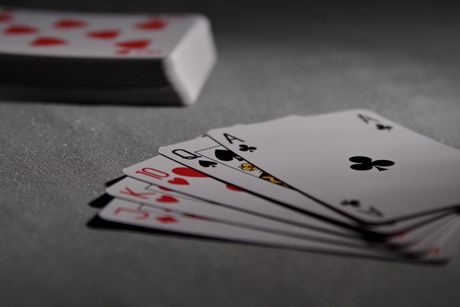 A stack of playing cards including a royal flush