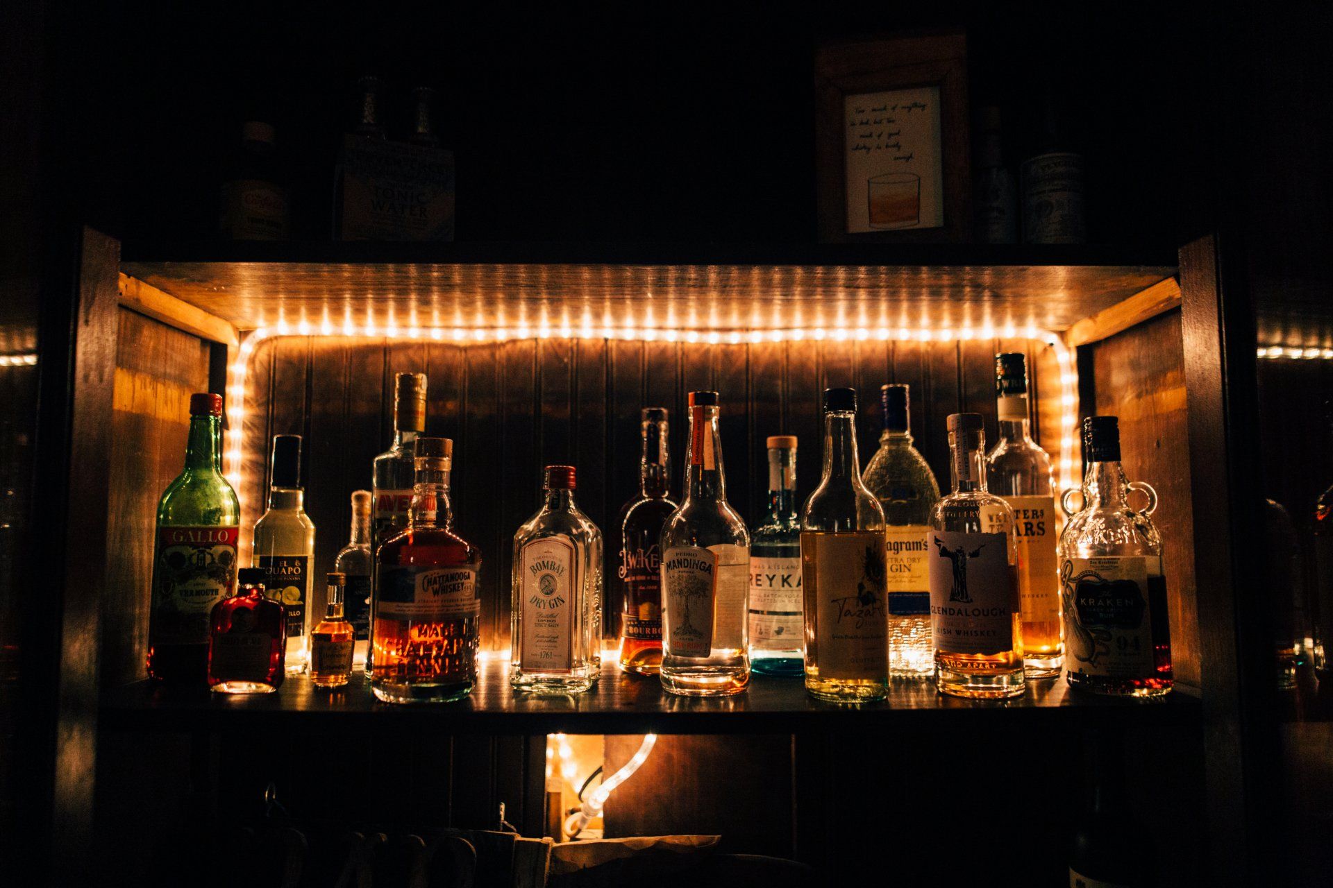 A shelf filled with lots of bottles of alcohol.