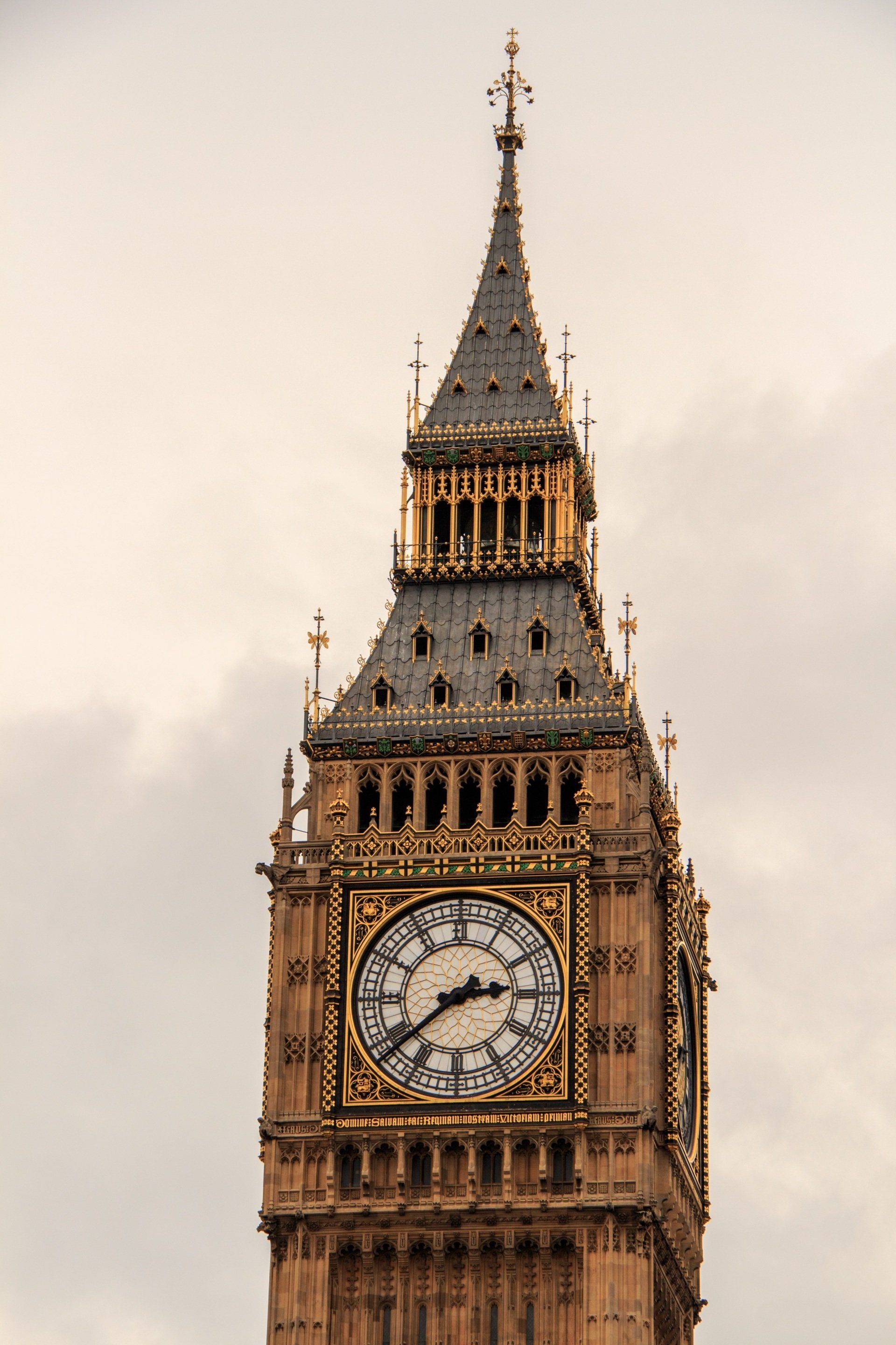 A large clock tower with a clock on it against a cloudy sky.