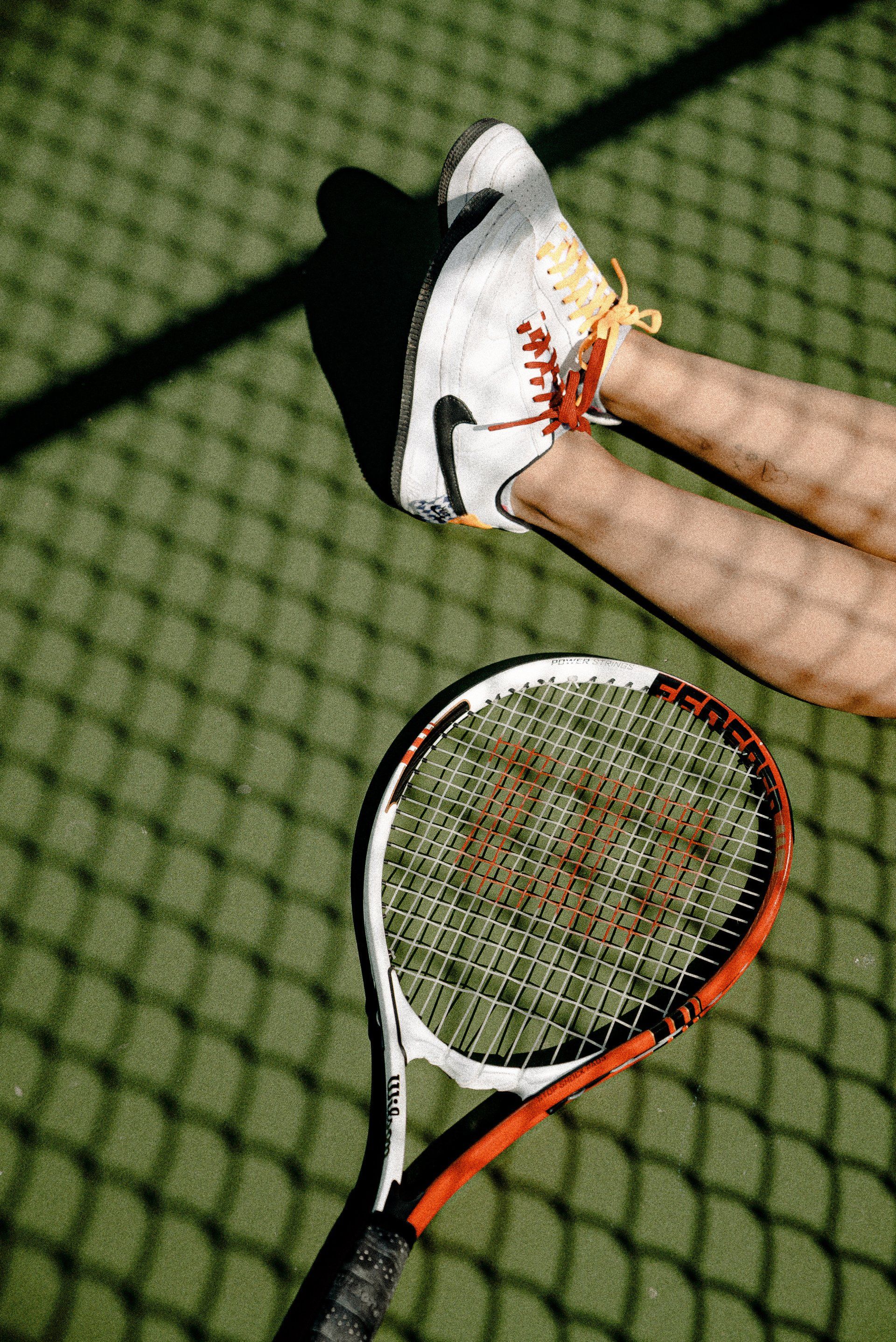 A person is holding a tennis racquet on a tennis court.