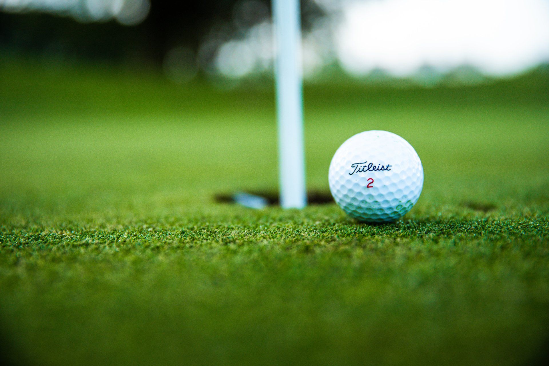 A golf ball is sitting on the green near the hole.