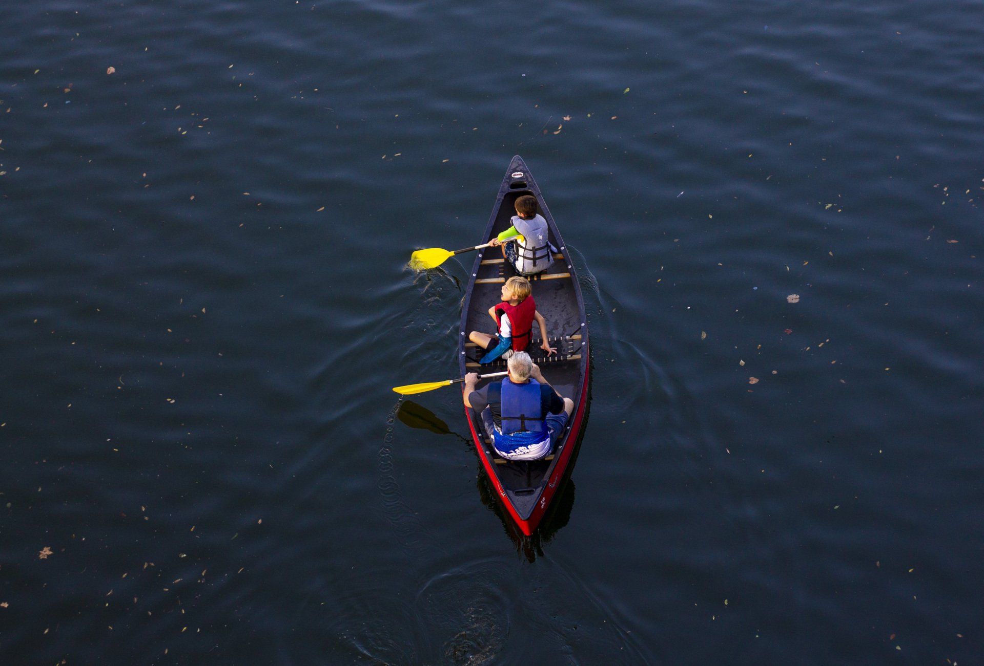 A group of people are paddling a canoe on a lake.
