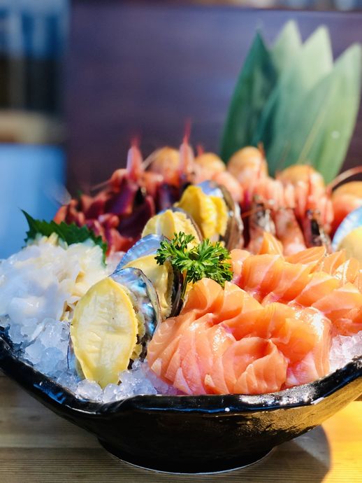 A close up of a bowl of food on ice on a table.