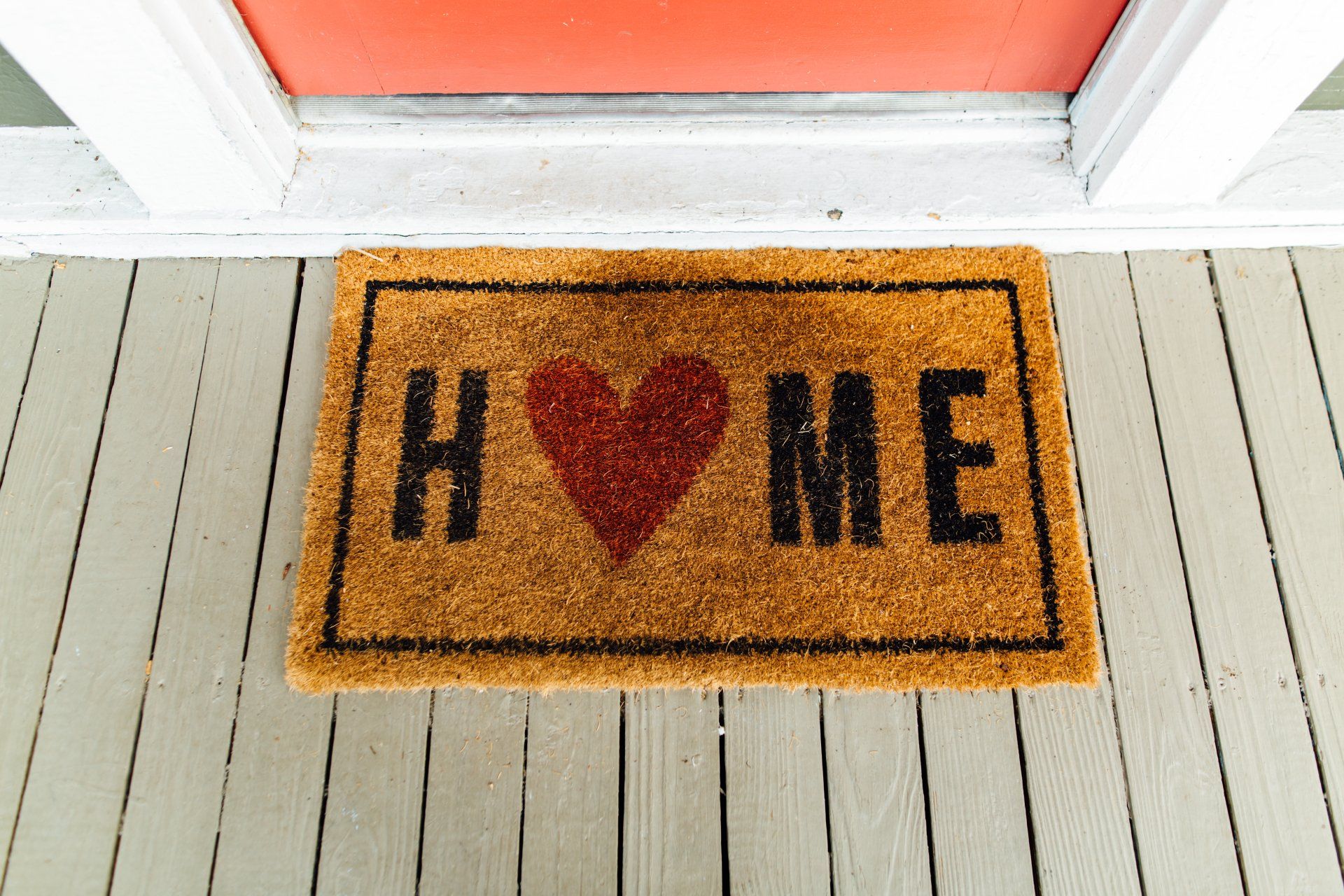 A door mat that says home with a heart on it