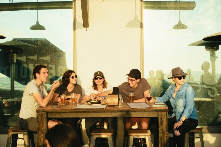 A group of people are sitting around a table in a restaurant.
