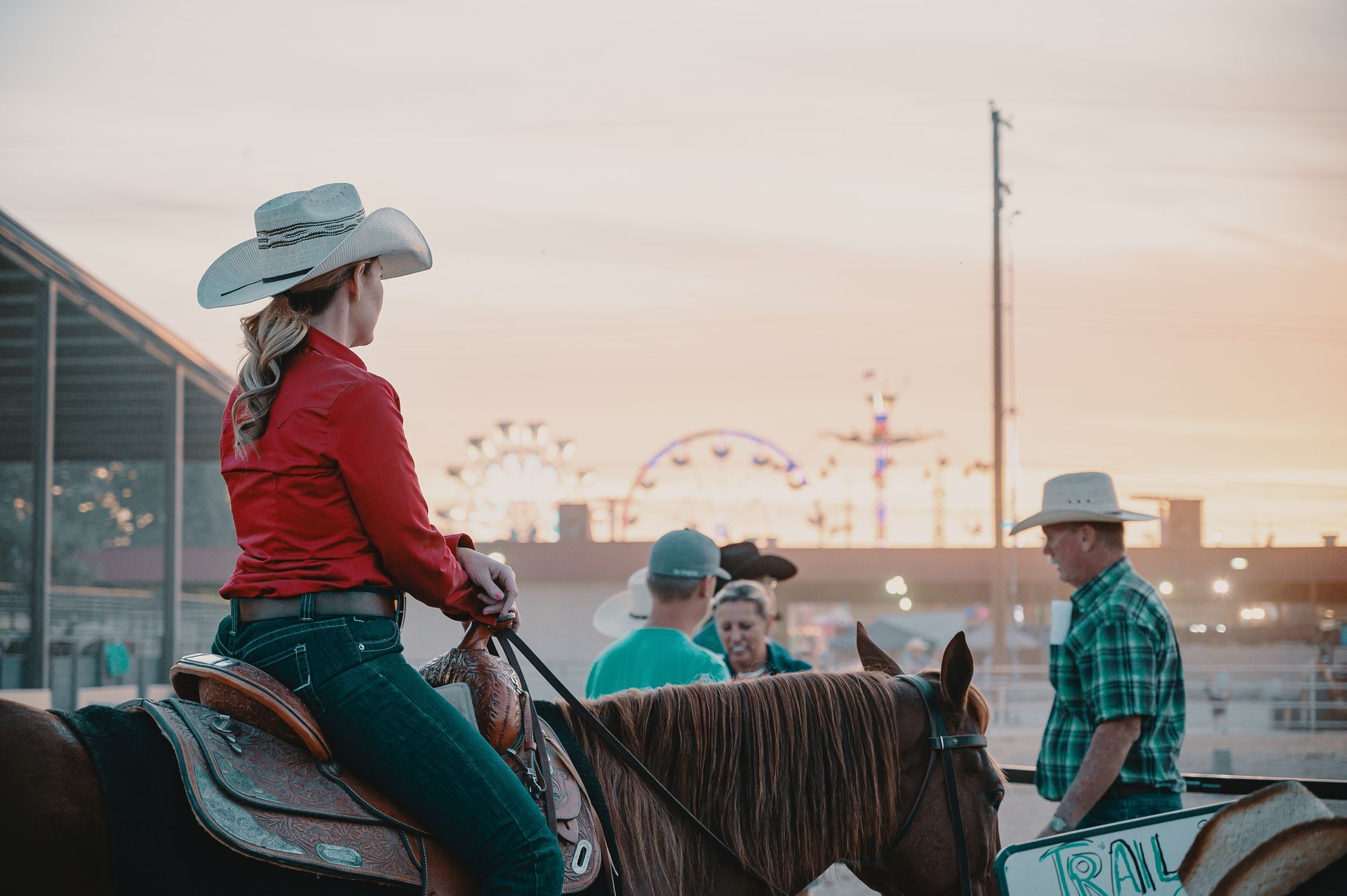 A woman in a cowboy hat is riding a horse.