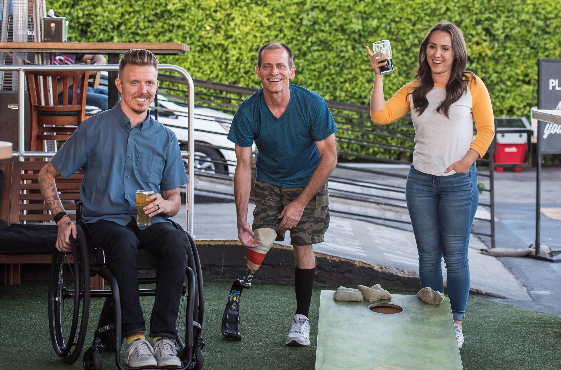Three individuals with disabilities smiling and engaging with each other, showcasing a sense of community and support.