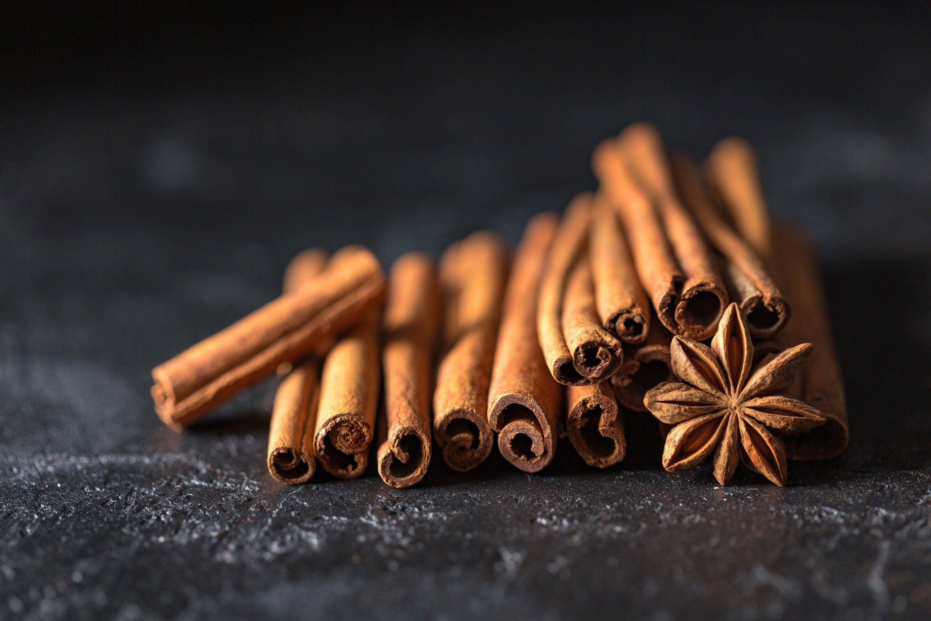 cinnamon sticks and star anise are stacked on top of each other on a table .