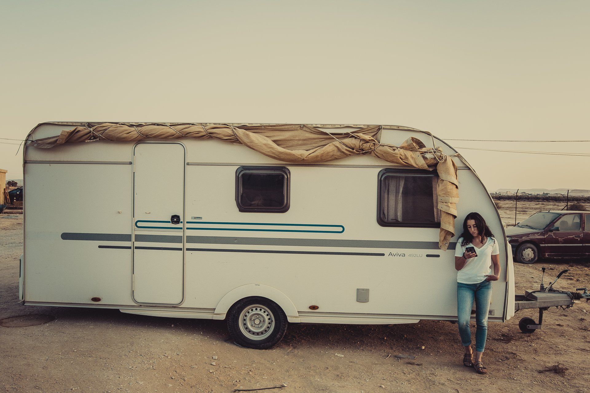 woman standing outside RV looking at phone