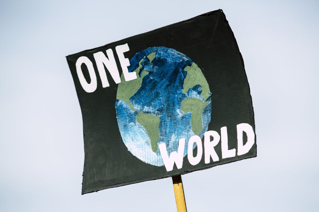 A sign that says one world with a picture of the earth on it.