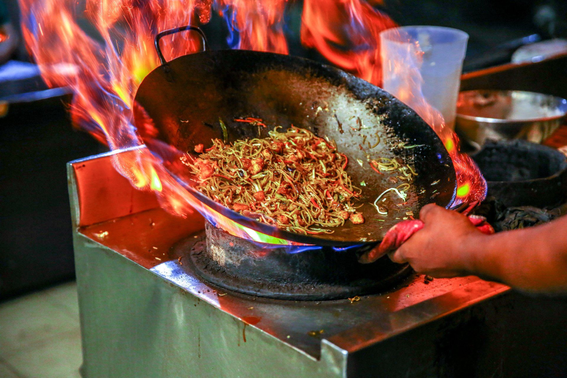 man cooking noodles in wok