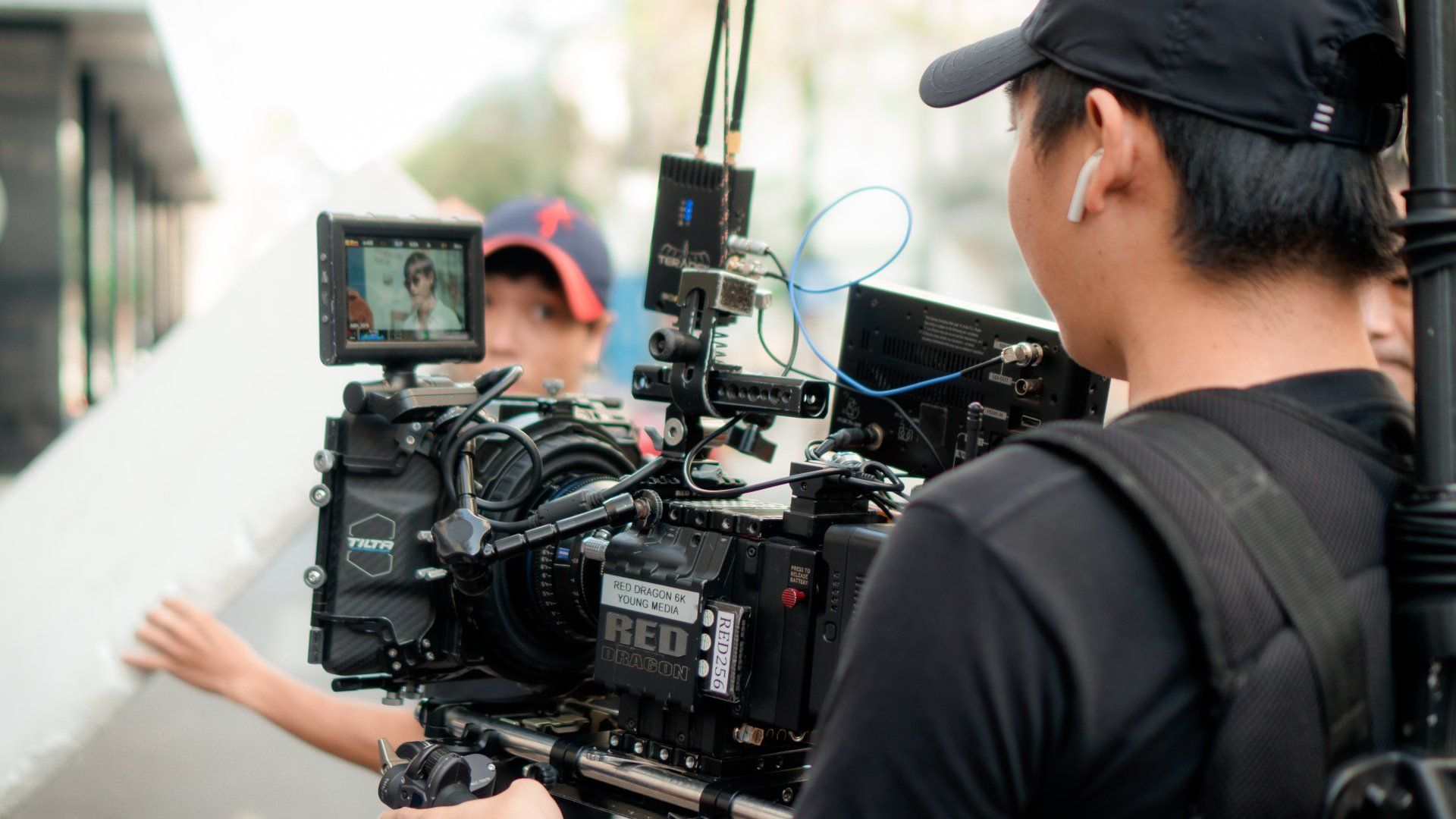 a man is standing in front of a red camera .