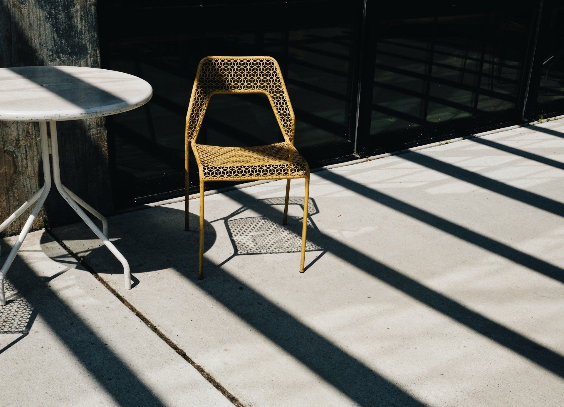 Chair by glass door, sunlight streaming in characterizing the art of deck and posh designs