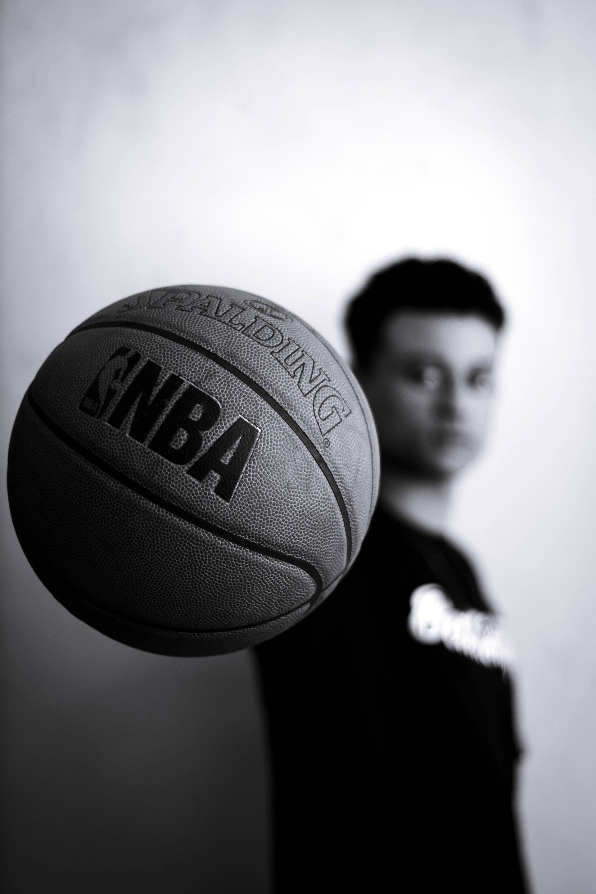 A man is holding a basketball in his hand in a black and white photo.