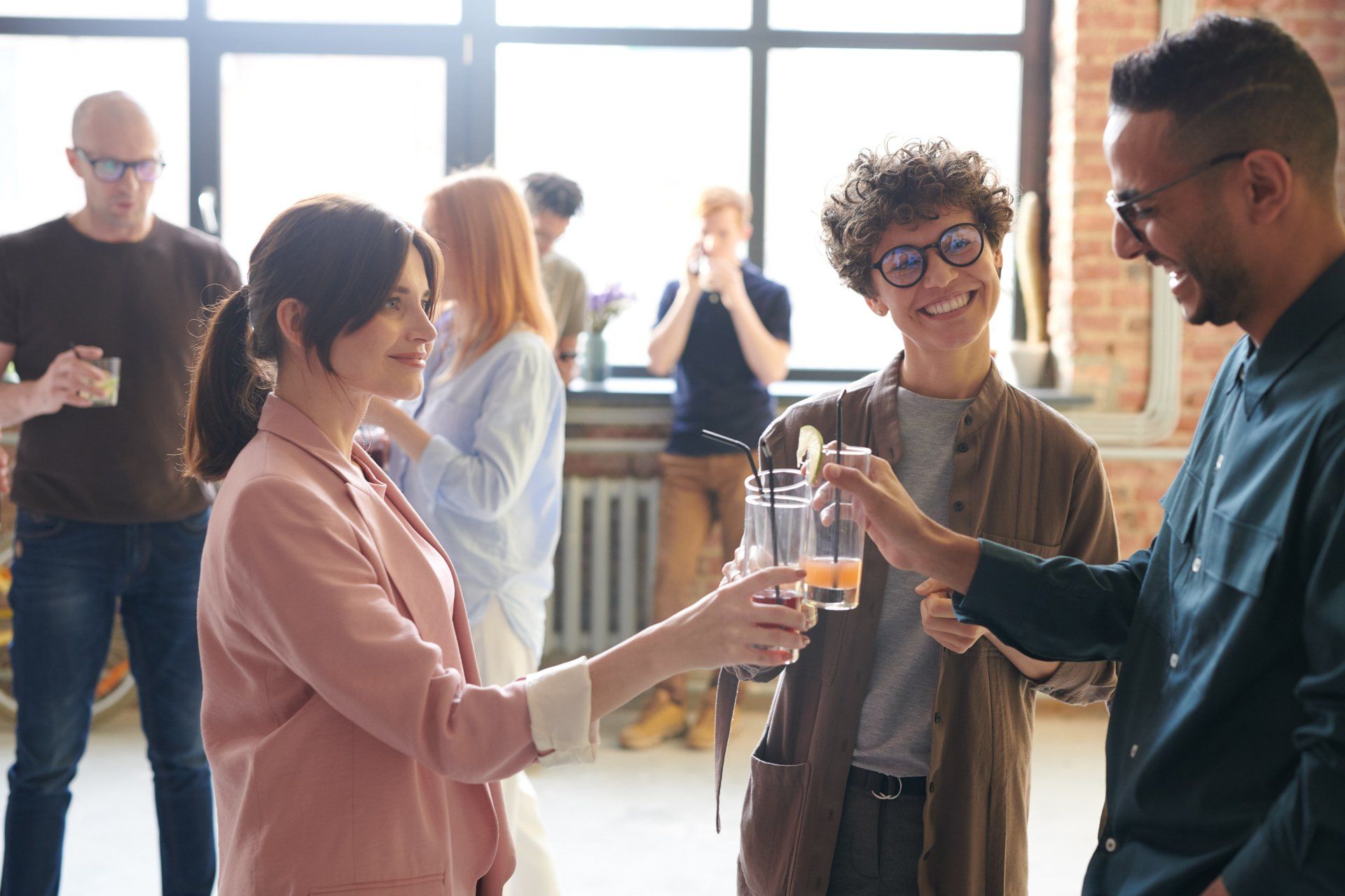 A group of people are toasting with drinks at a party.