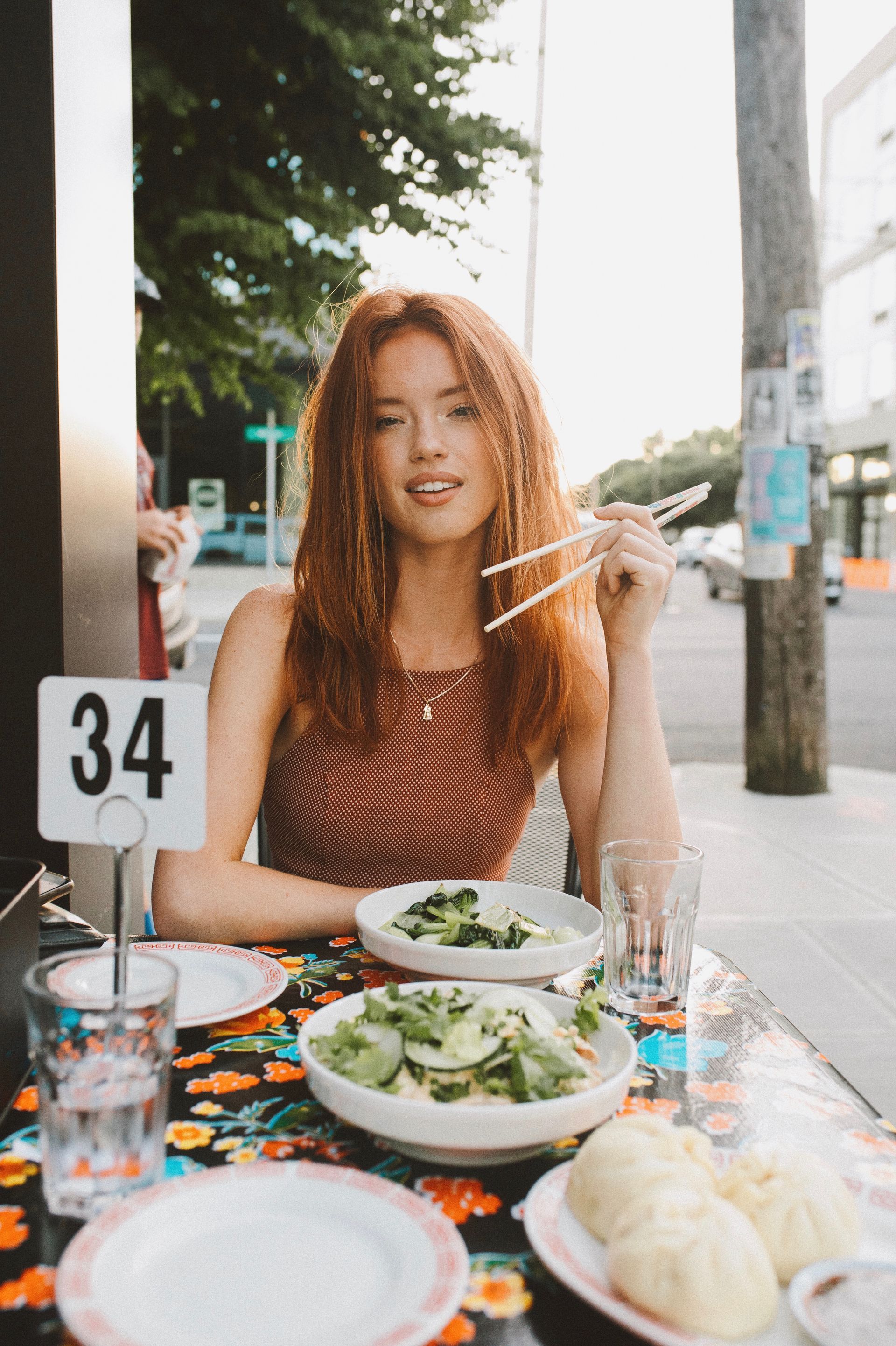 Attractive woman eating a salad. Happy with her photos
