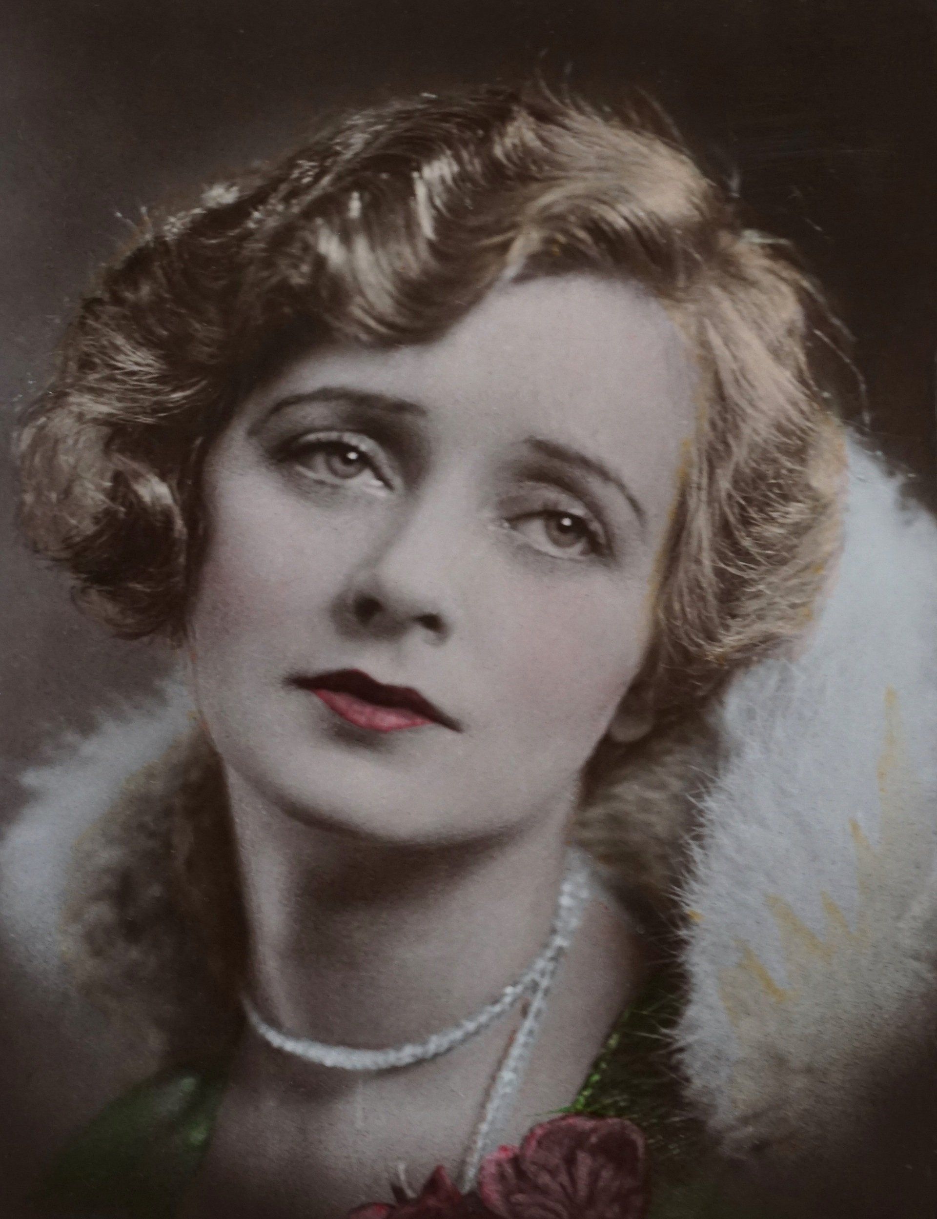 une femme portant un collier de perles et un manteau de fourrure