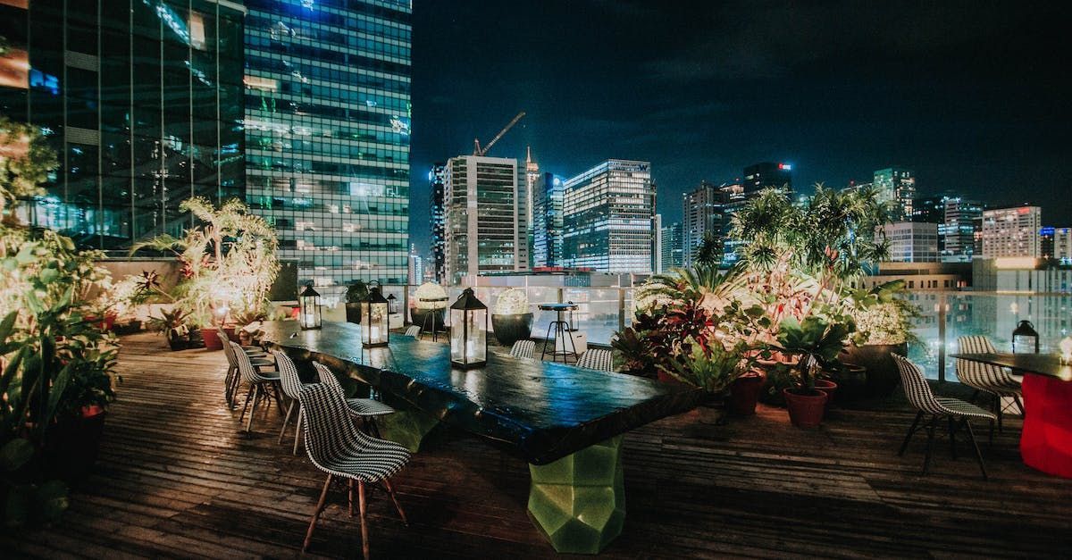 A swimming pool on a rooftop at night with a city in the background.