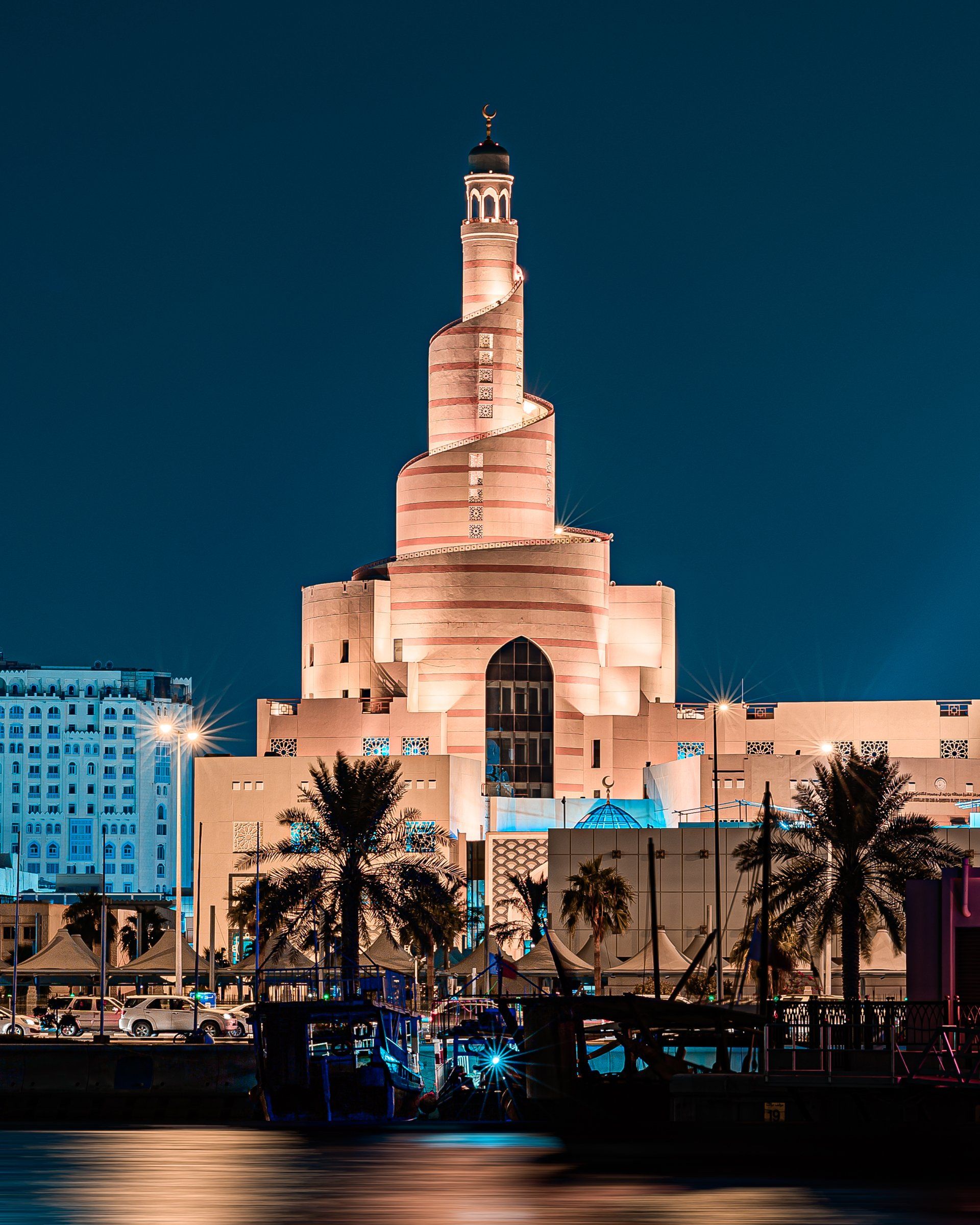 A large building with a tower on top of it is lit up at night.