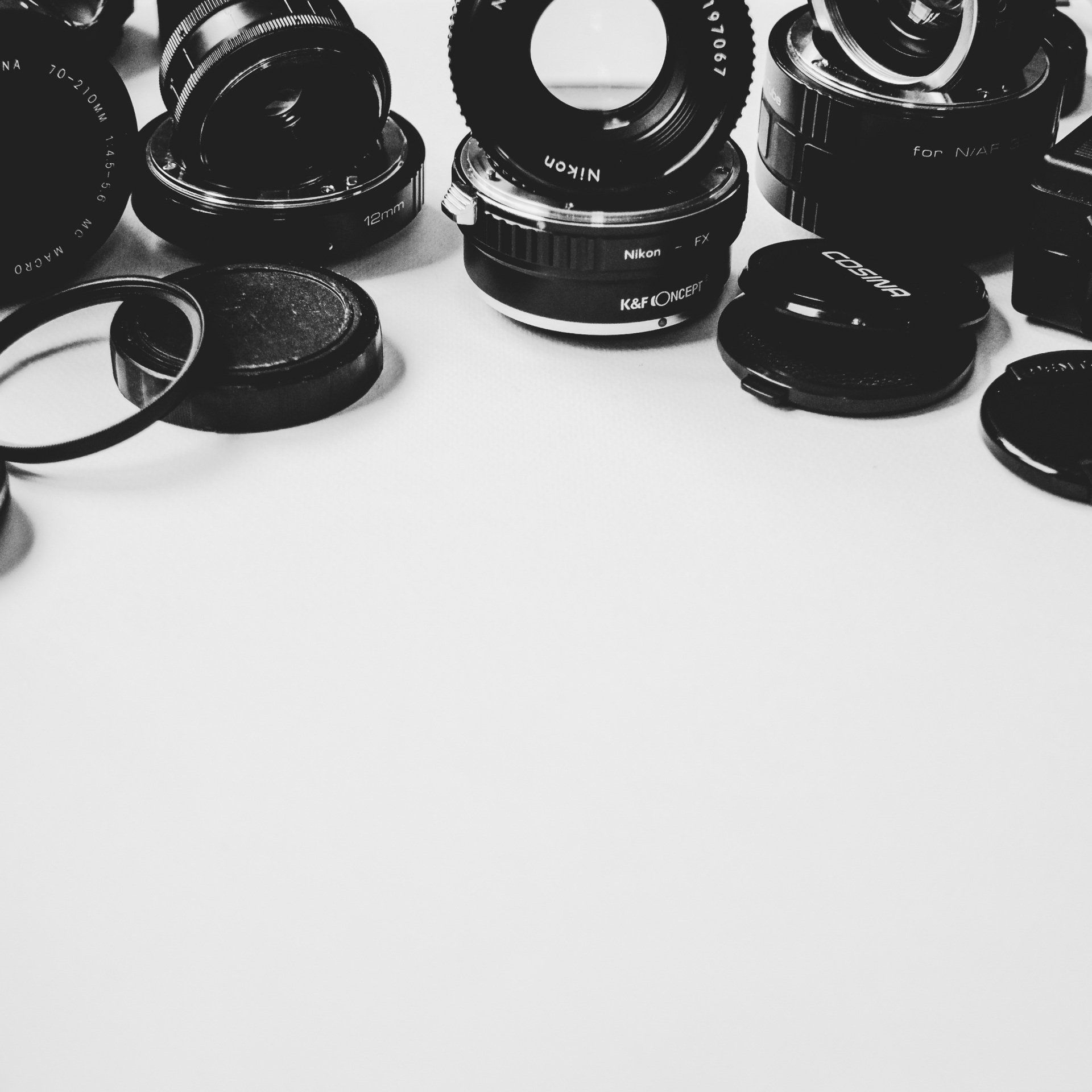 A bunch of camera lenses are on a white surface