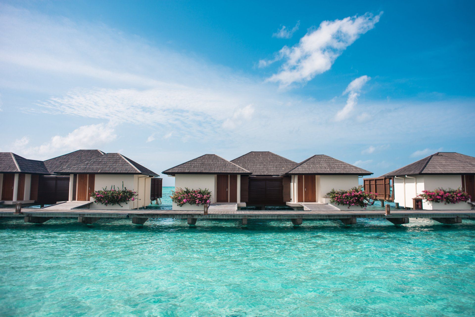 A row of houses on stilts in the middle of the ocean.