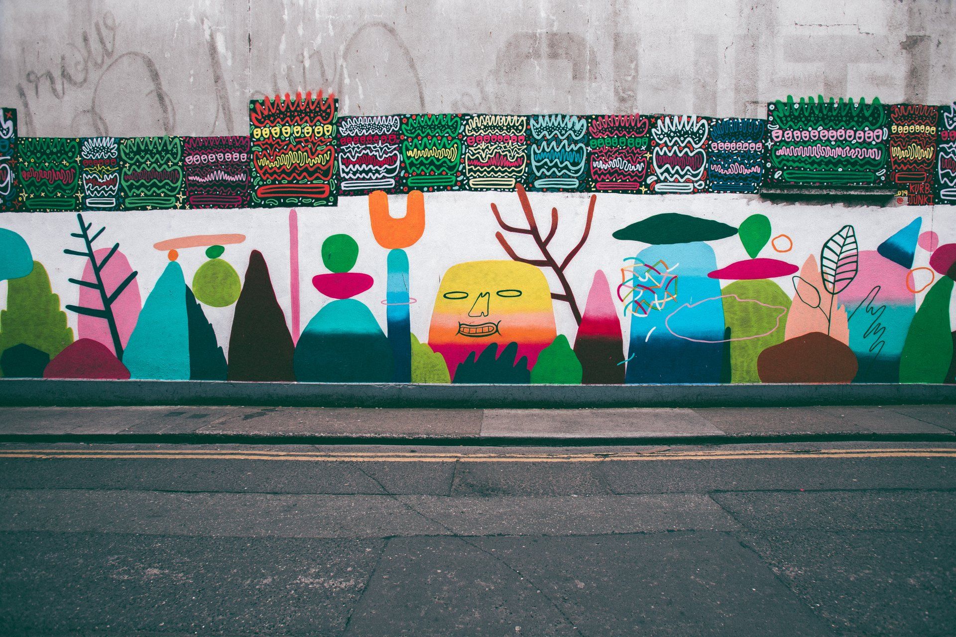 A wall with a lot of colorful paintings on it