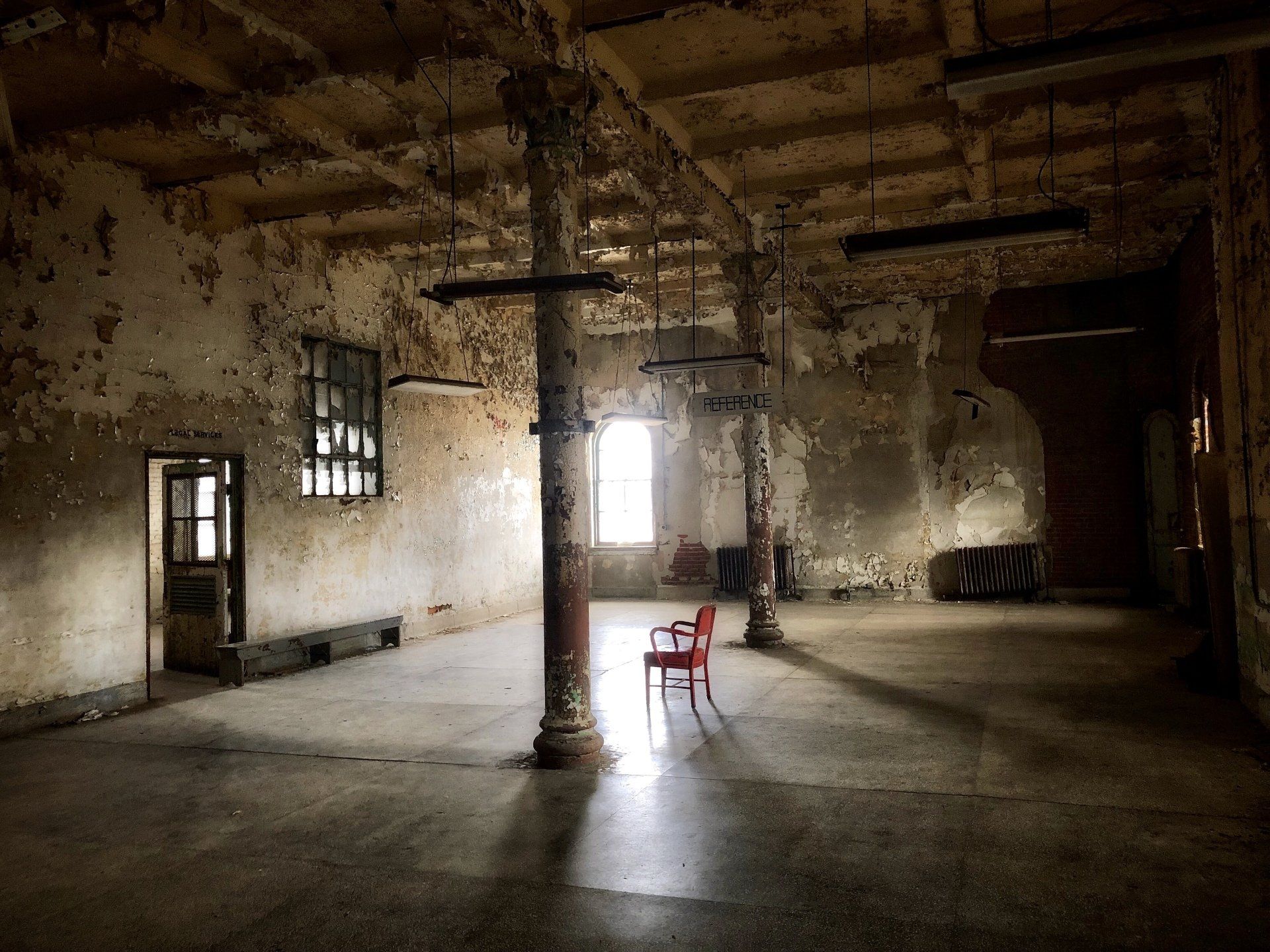 An empty room with a red chair in the middle