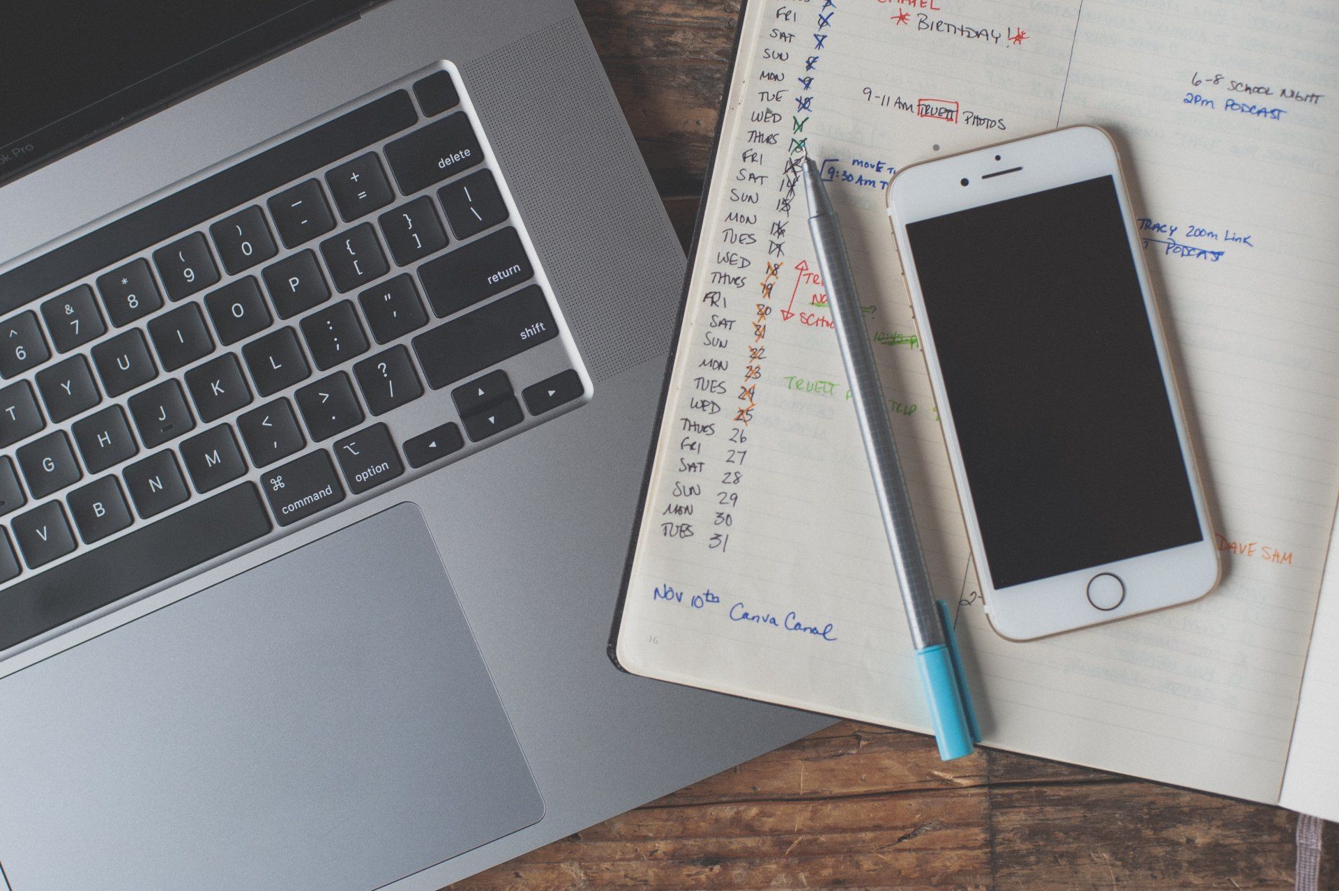 image of a computer, pen, phone, and social media calendar