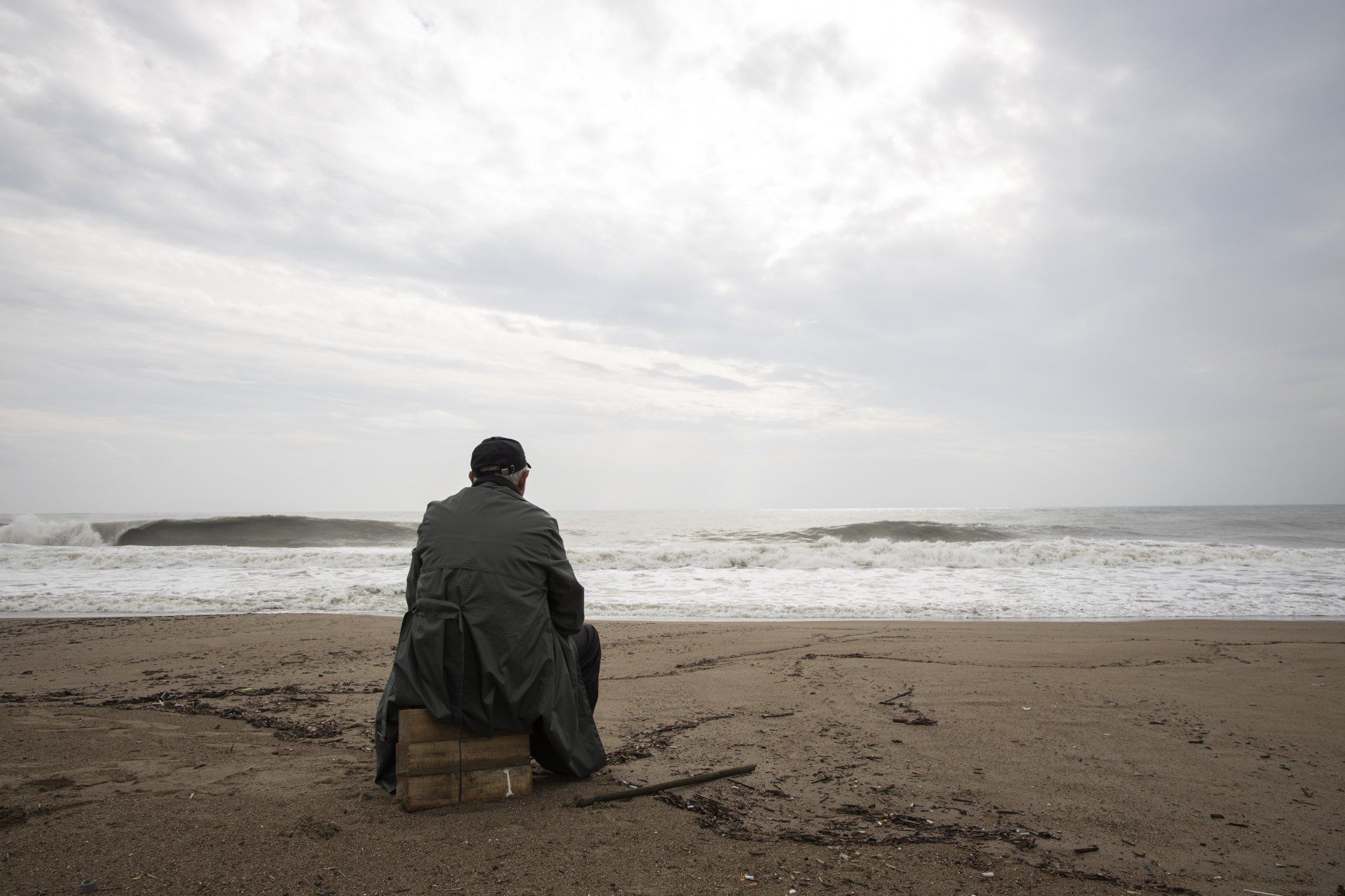 Man sitting alone on a sandy beach