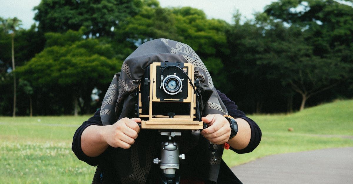 A person is holding a camera in front of their face.