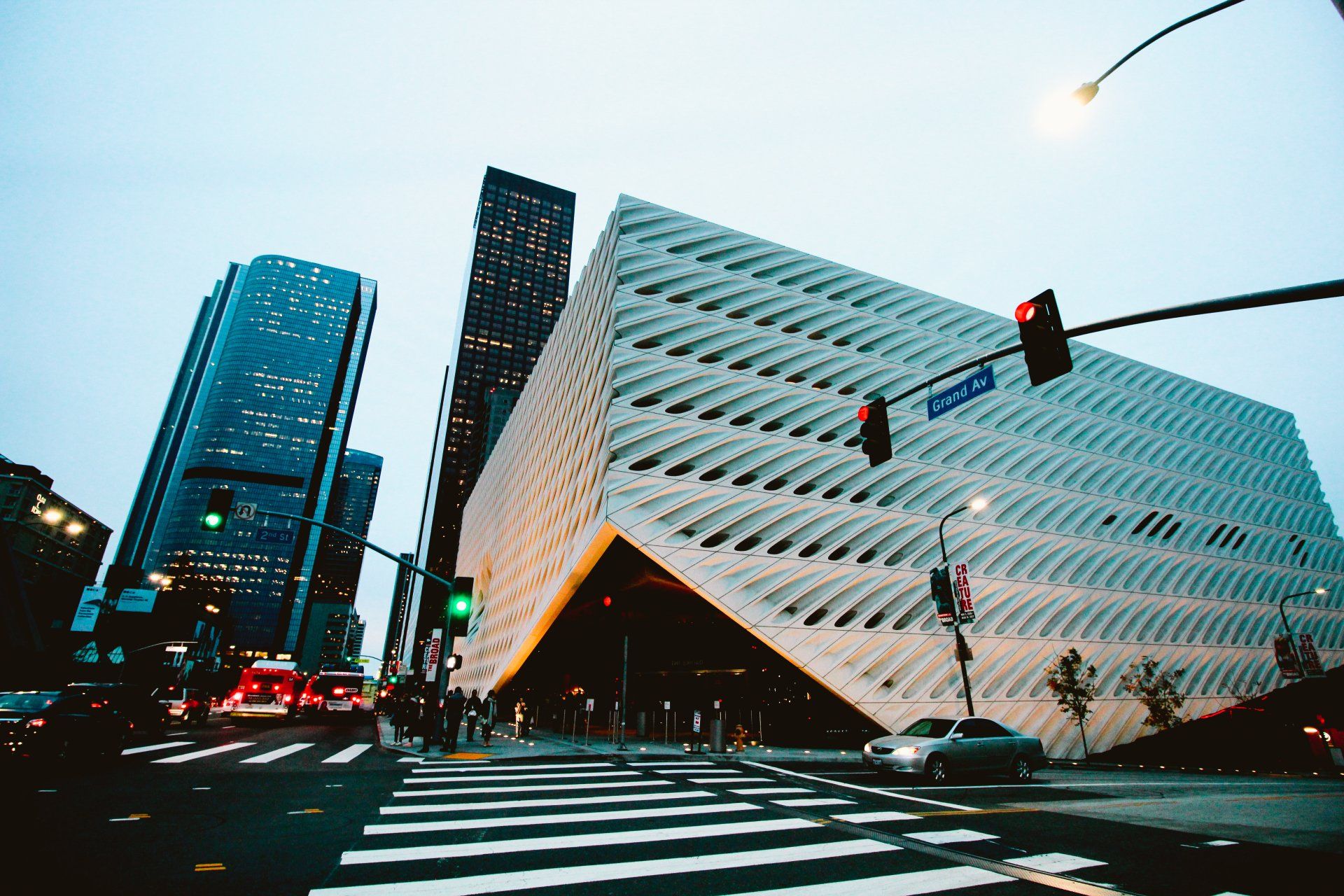 A large building is sitting on the corner of a city street.