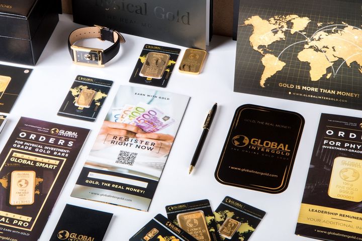 A table topped with a variety of gold products including a bracelet and a pen