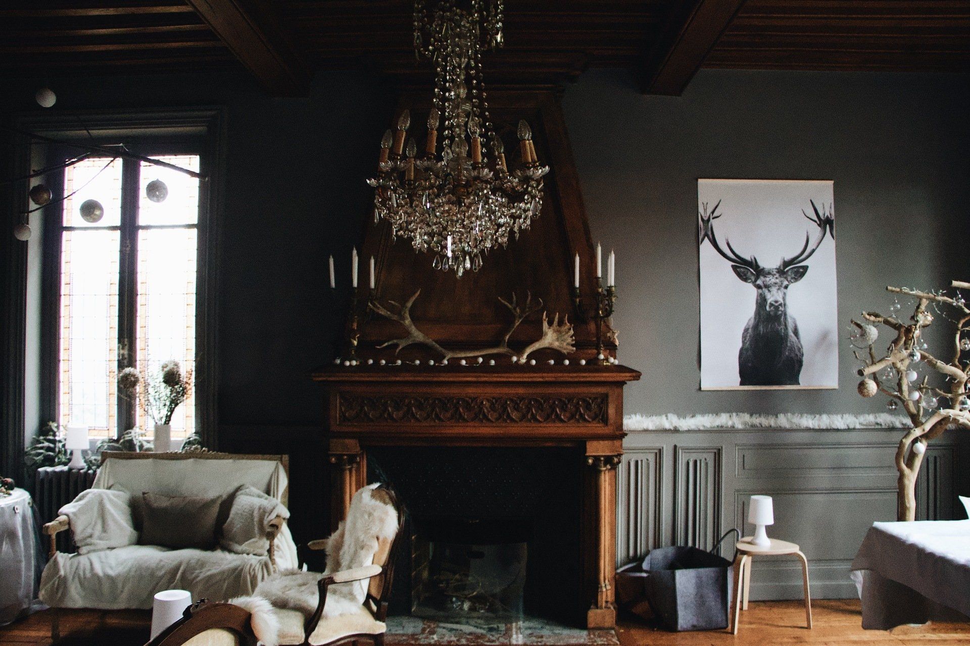 Ornate living room with a fireplace, chandelier, and deer art.