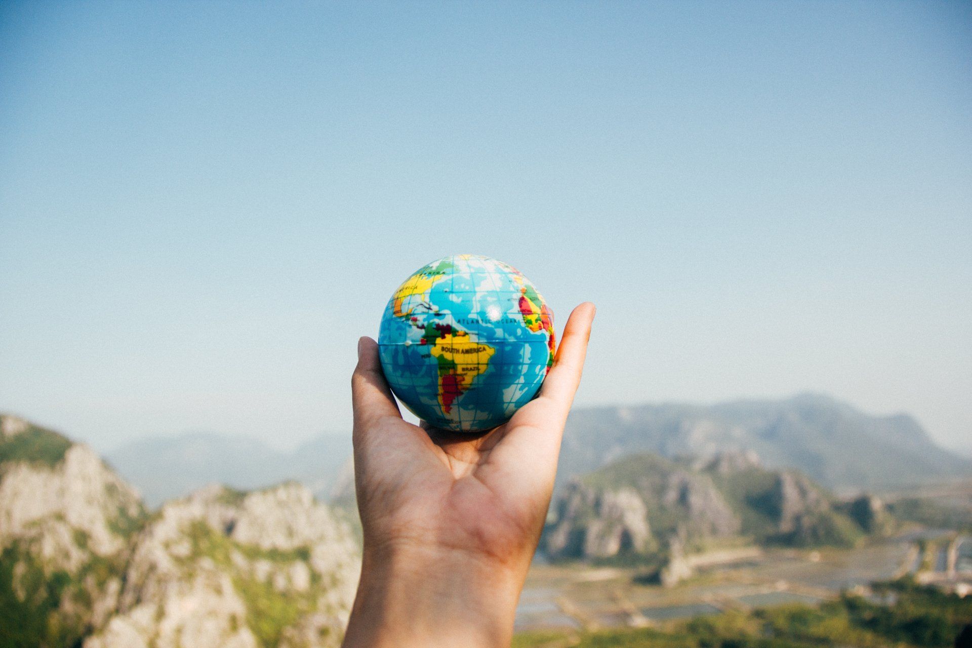 A person is holding a small globe in their hand.