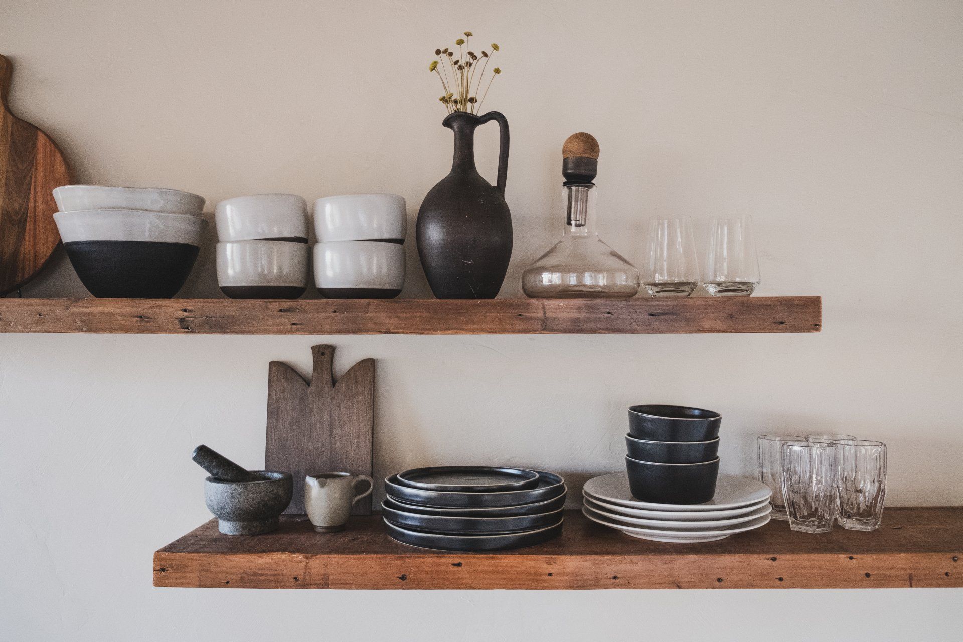a wooden shelf with plates , bowls , glasses and a vase on it . 5 Kitchen Trends for 2024