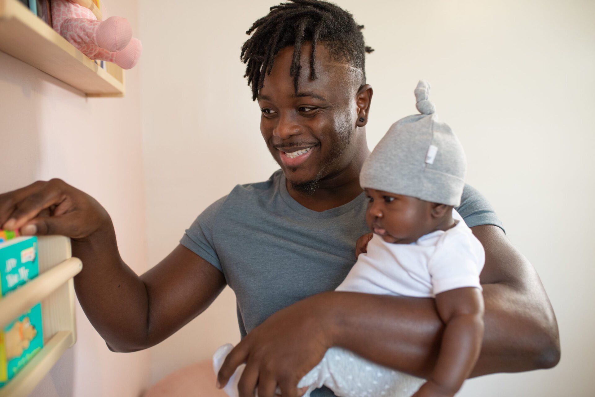 A man is holding a baby in his arms and smiling.
