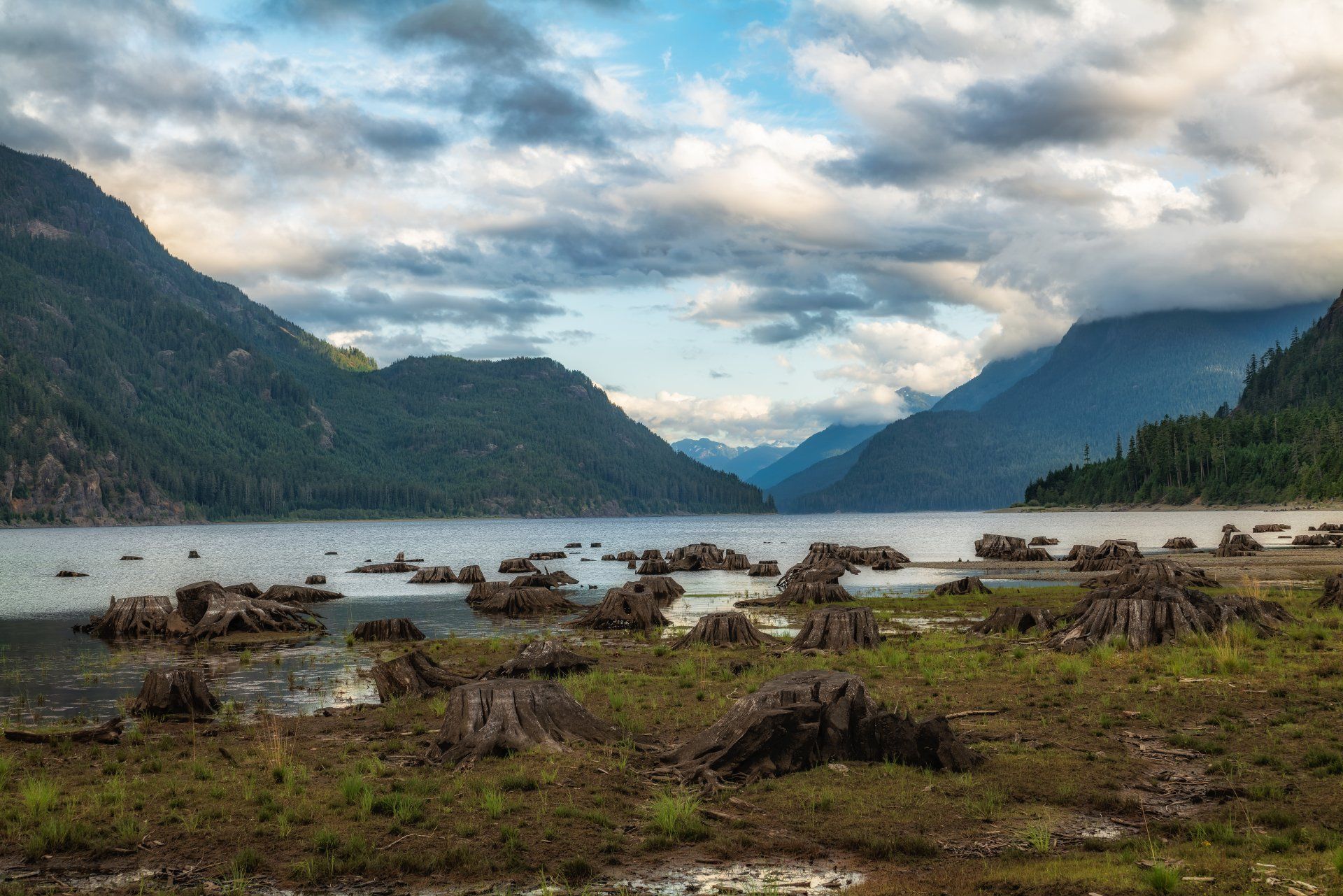 A lake surrounded by mountains on a cloudy day