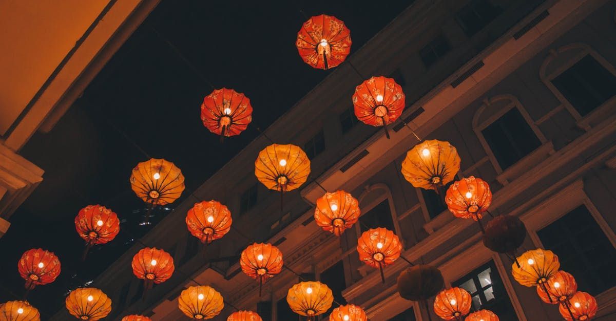A bunch of lanterns are hanging from the ceiling of a building.