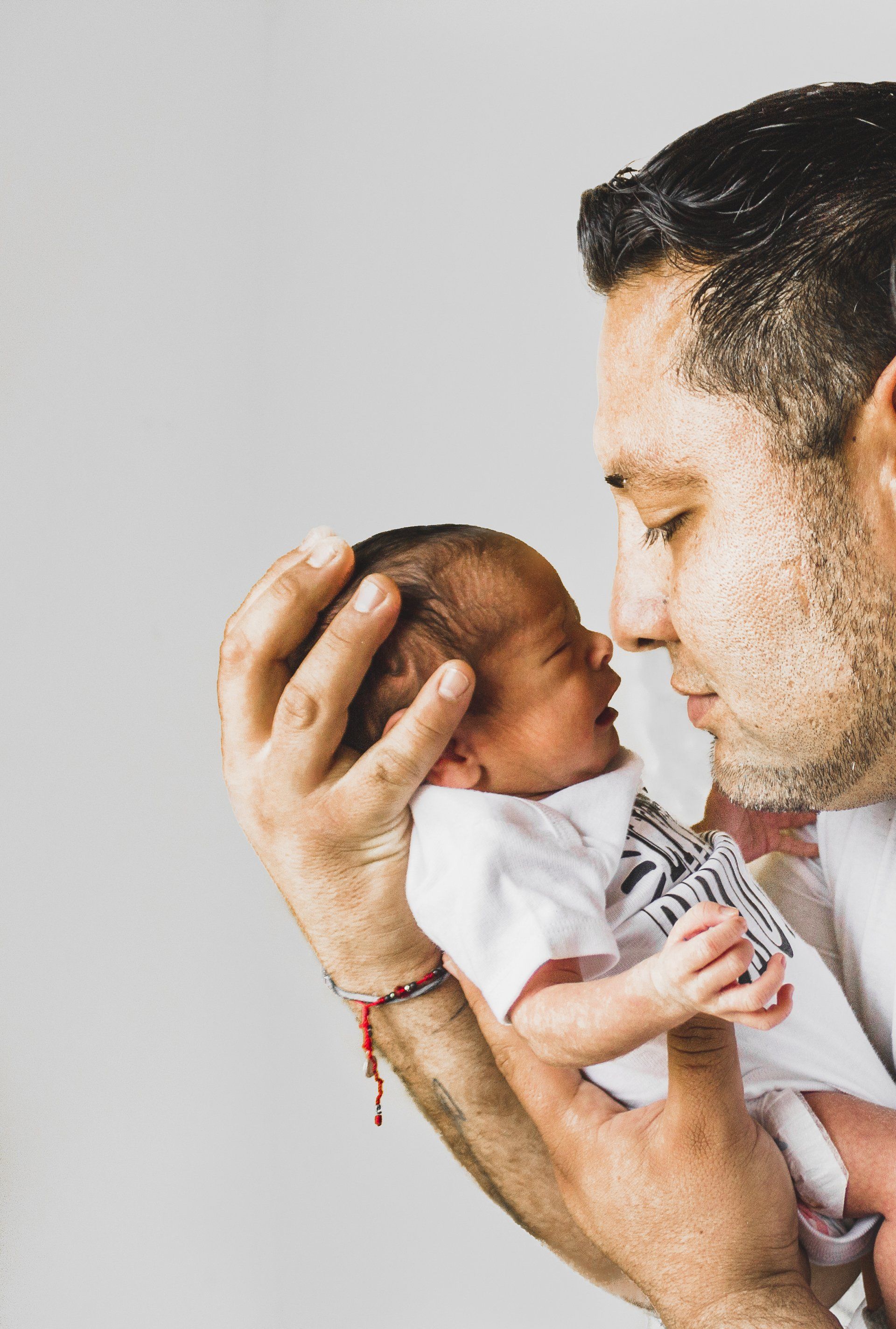 A man is holding a newborn baby in his arms.